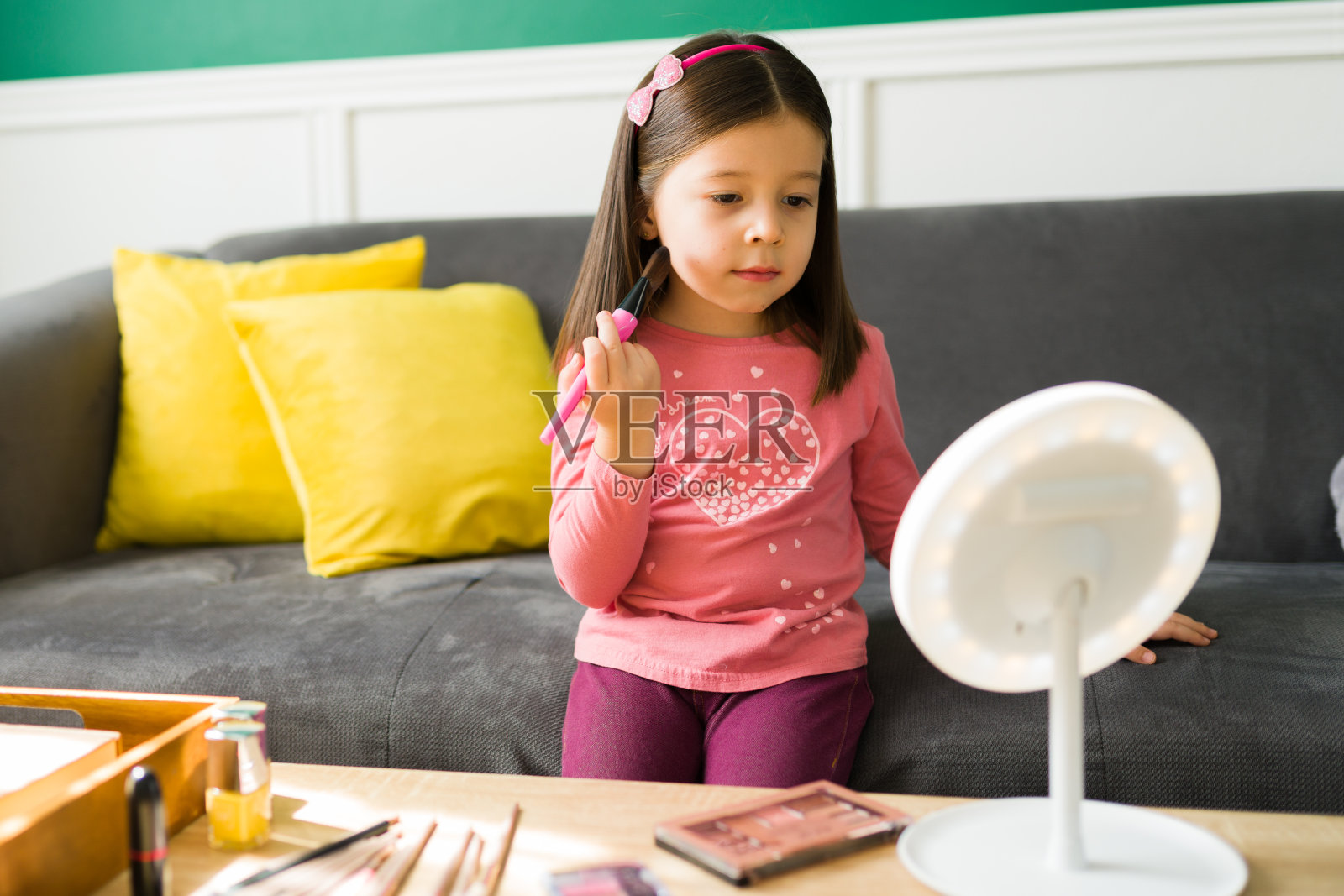 漂亮的孩子在玩她妈妈的化妆品照片摄影图片