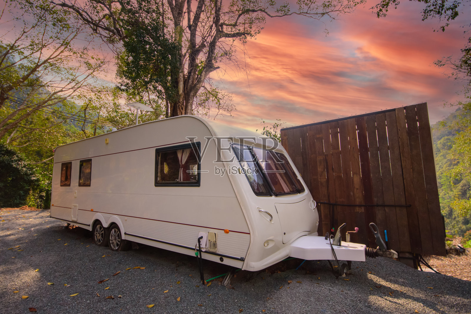 在美丽的夕阳下，露营车停在草地上照片摄影图片