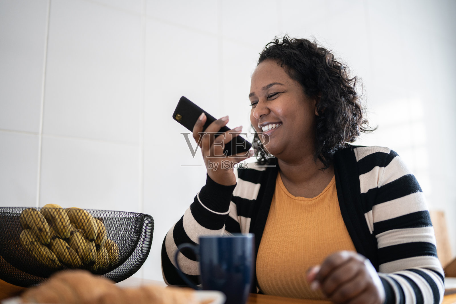 中年妇女在家用智能手机通话照片摄影图片