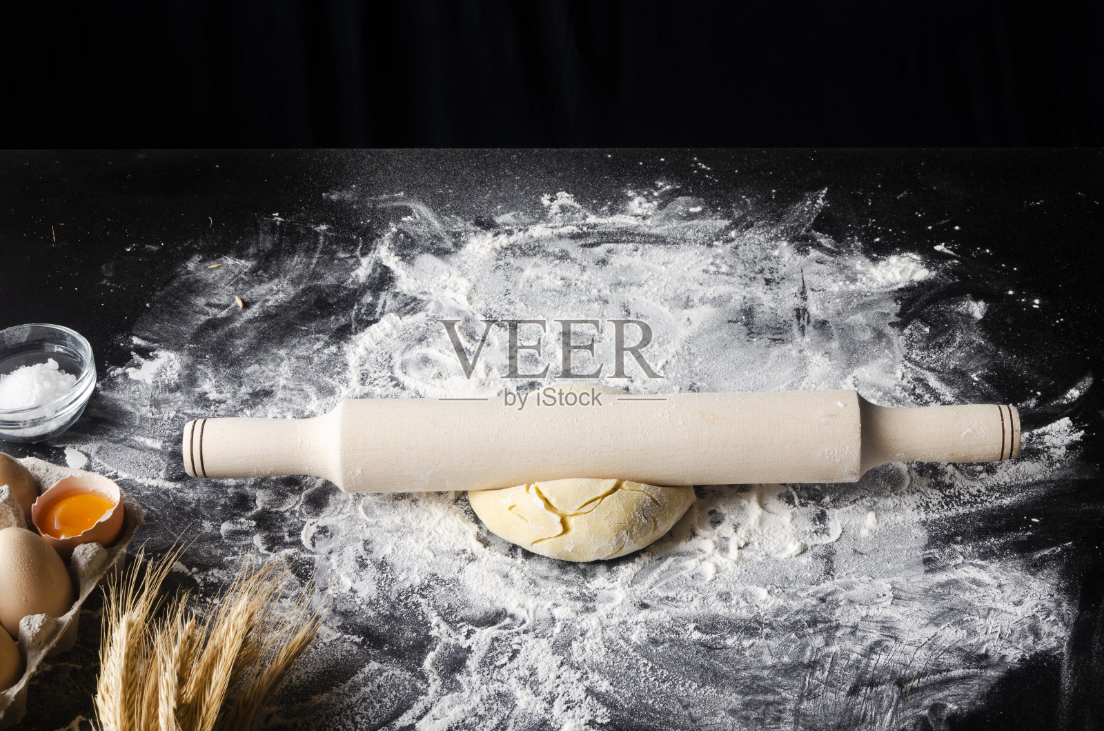 烘烤背景与您的文字自由空间。黑色的桌子上放着擀面杖和面粉。本空间照片摄影图片