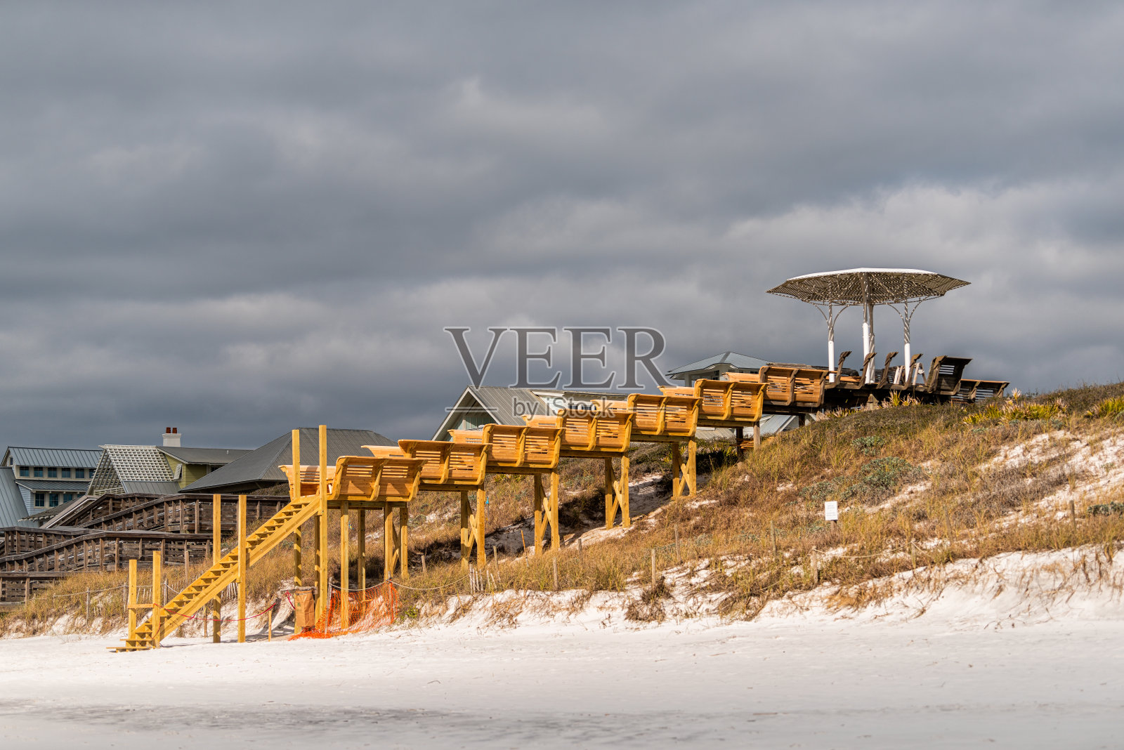 凉亭和木制台阶木板路建设海滩与多云的暴风雨天气的天空，佛罗里达州的墨西哥湾狭长地带照片摄影图片