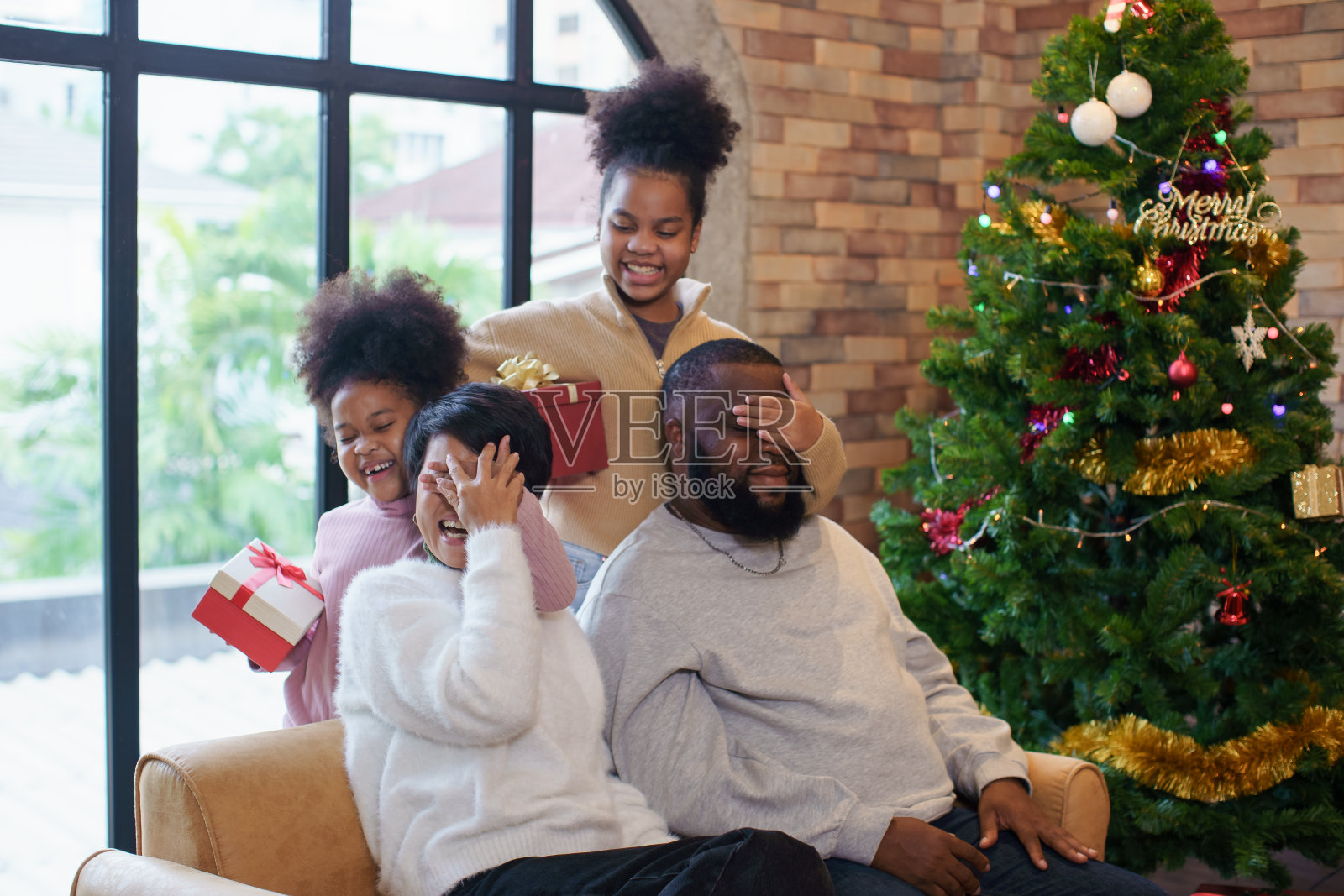 黑人家庭在公寓里用礼物盒一起庆祝圣诞节照片摄影图片