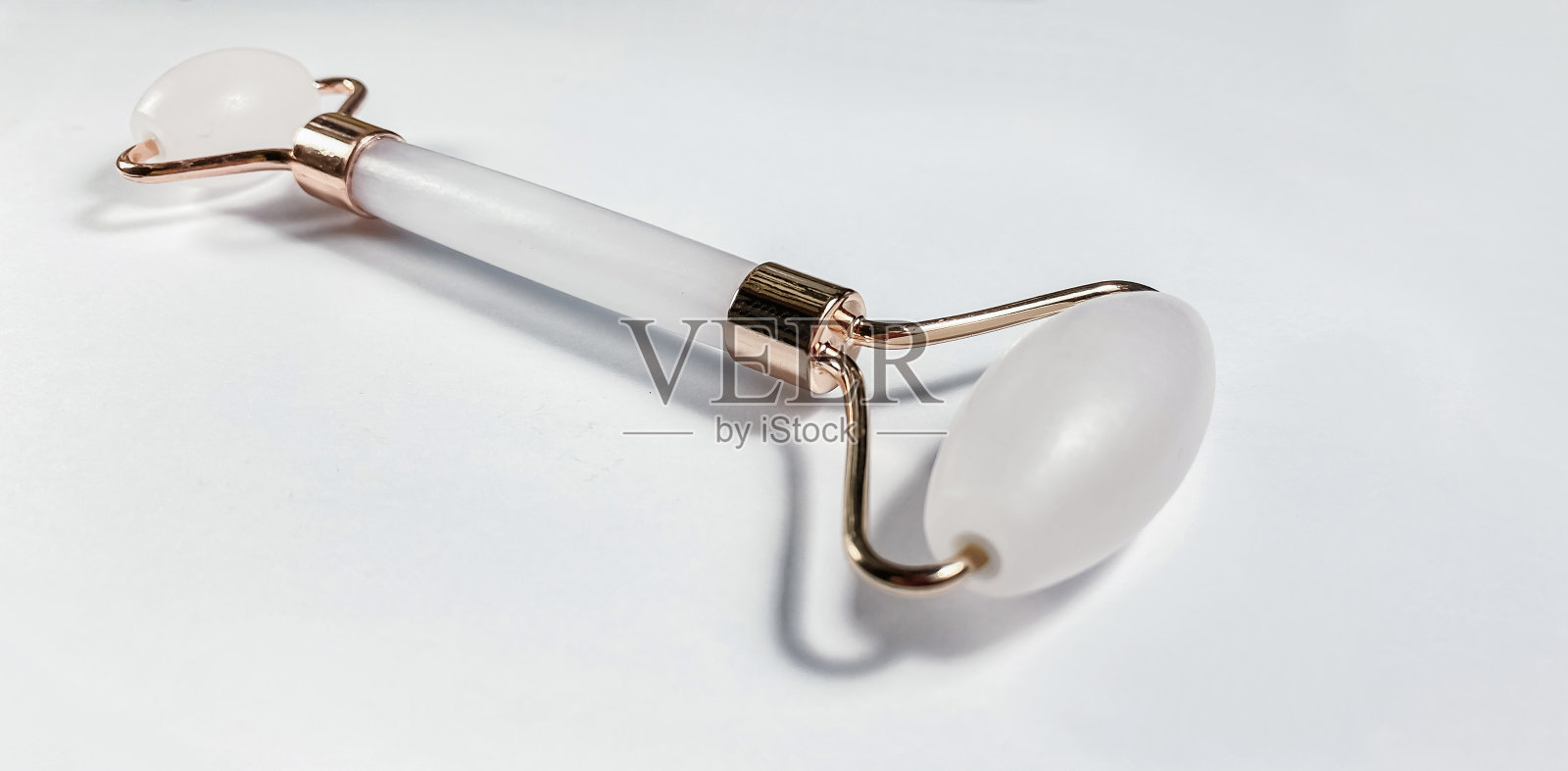 白色按摩石英辊为脸特写孤立在白色背景。女性的美容和护理理念照片摄影图片