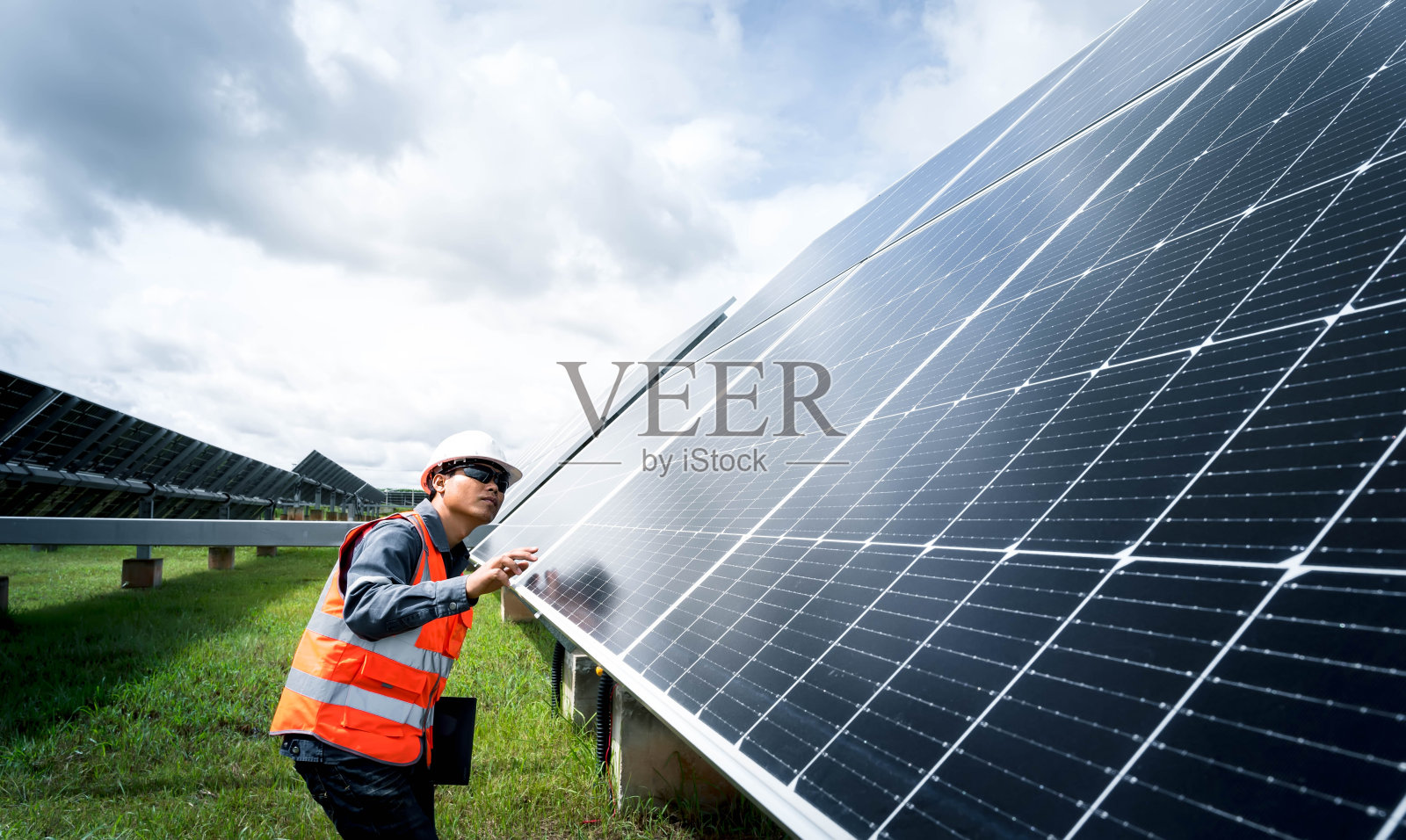 太阳能农场(太阳能电池板)与工程师检查系统的运行，节约世界能源的替代能源，清洁能源生产的光伏组件的想法照片摄影图片