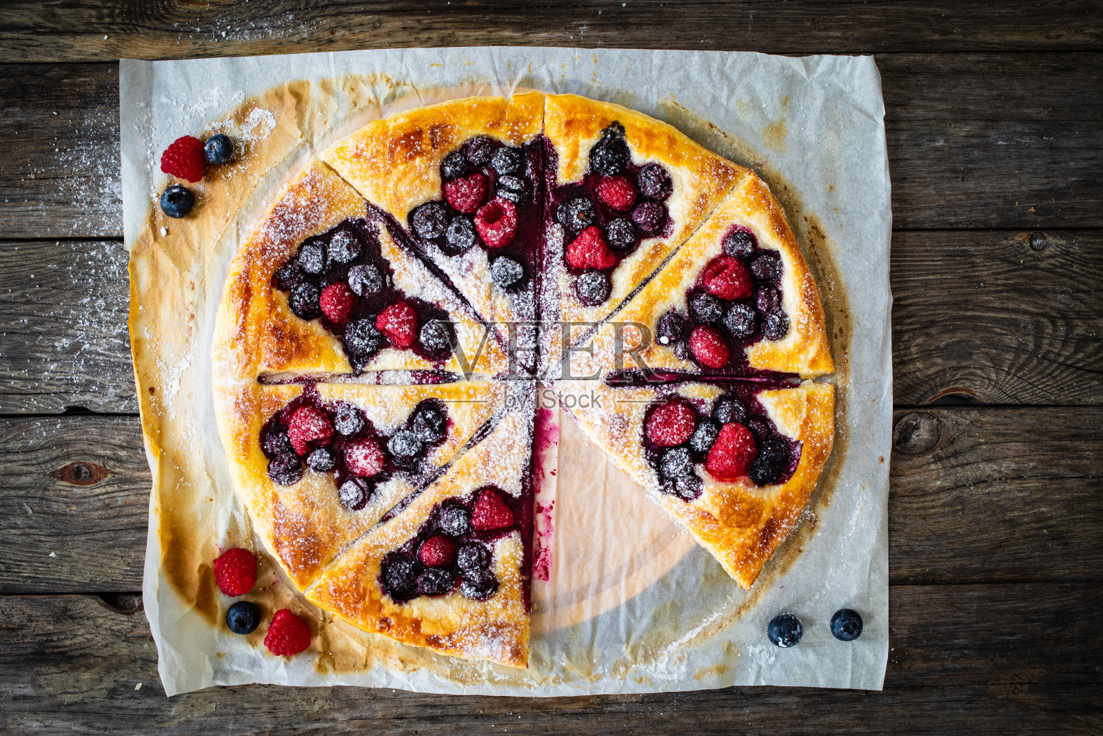 烤纸上有覆盆子和蓝莓的酥皮照片摄影图片