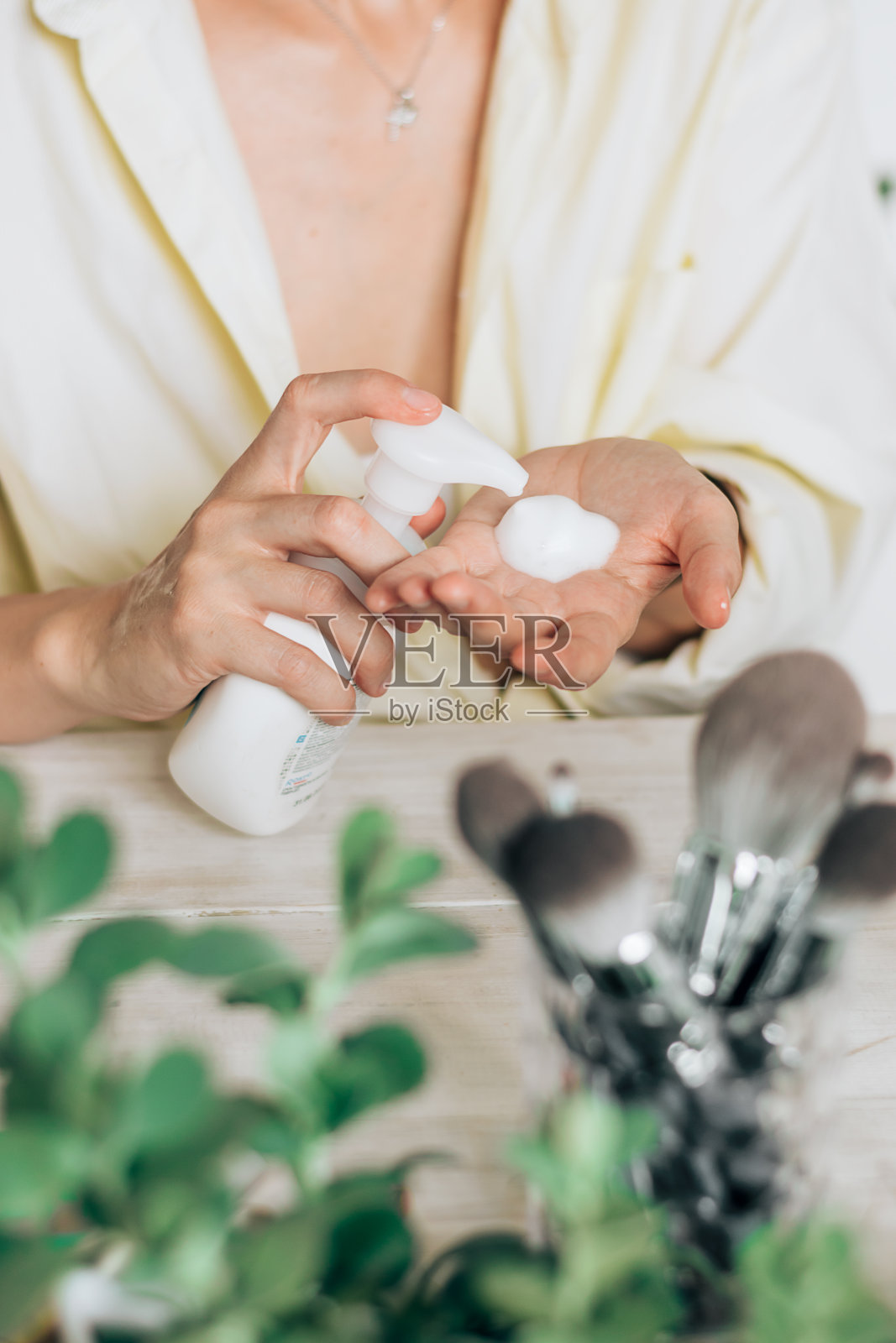 女人的手特写，挤压化妆品。在家自我保健。美丽的概念。照片摄影图片