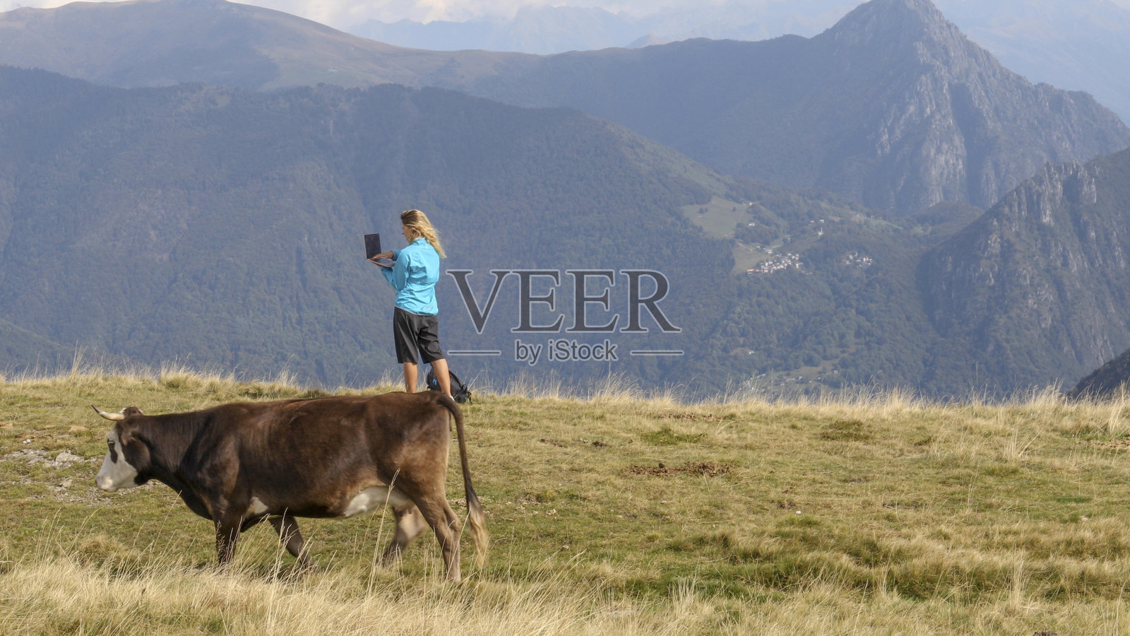 女徒步旅行者在山脊上用笔记本电脑工作照片摄影图片