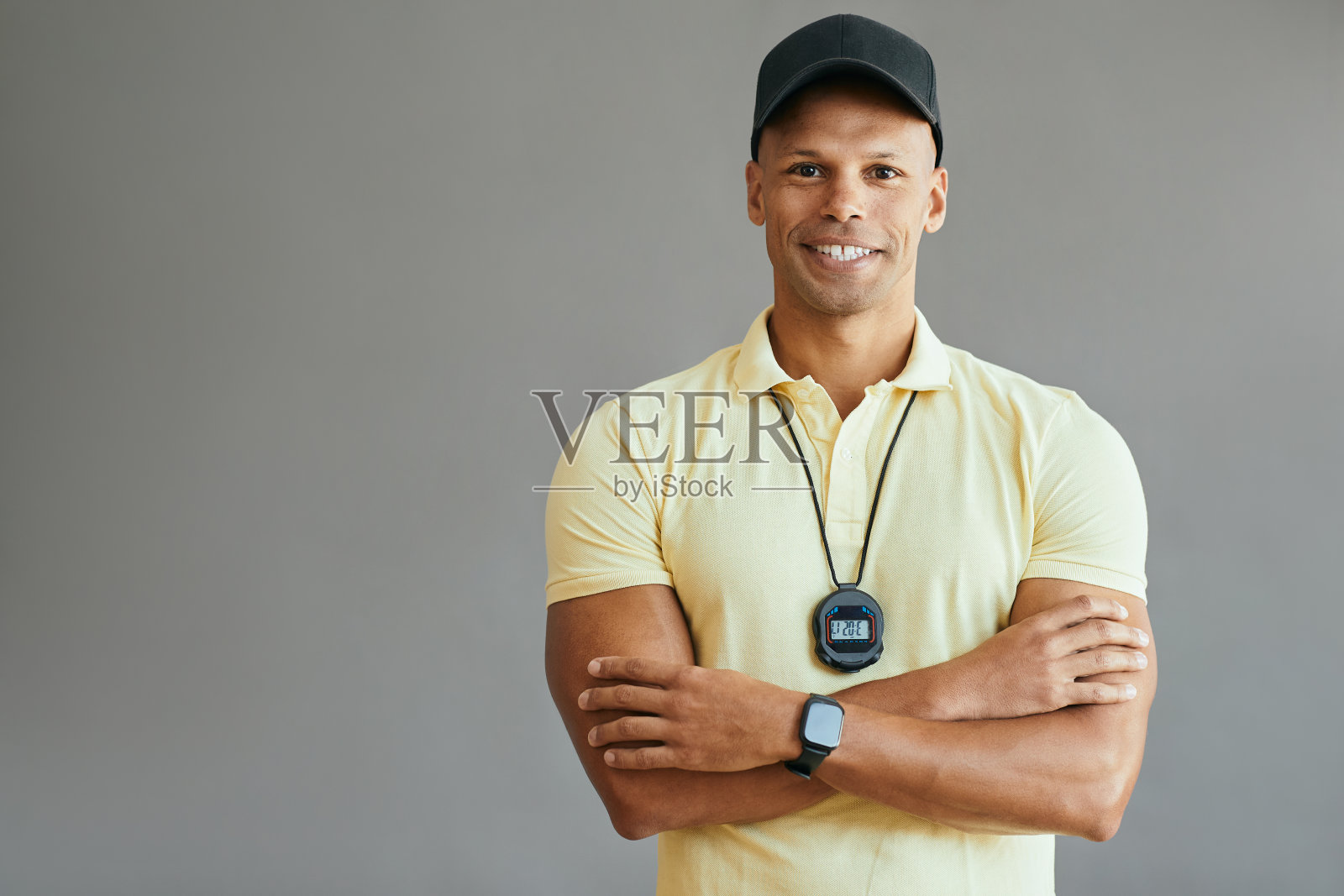 自信的私人教练双臂交叉站着看着相机。照片摄影图片