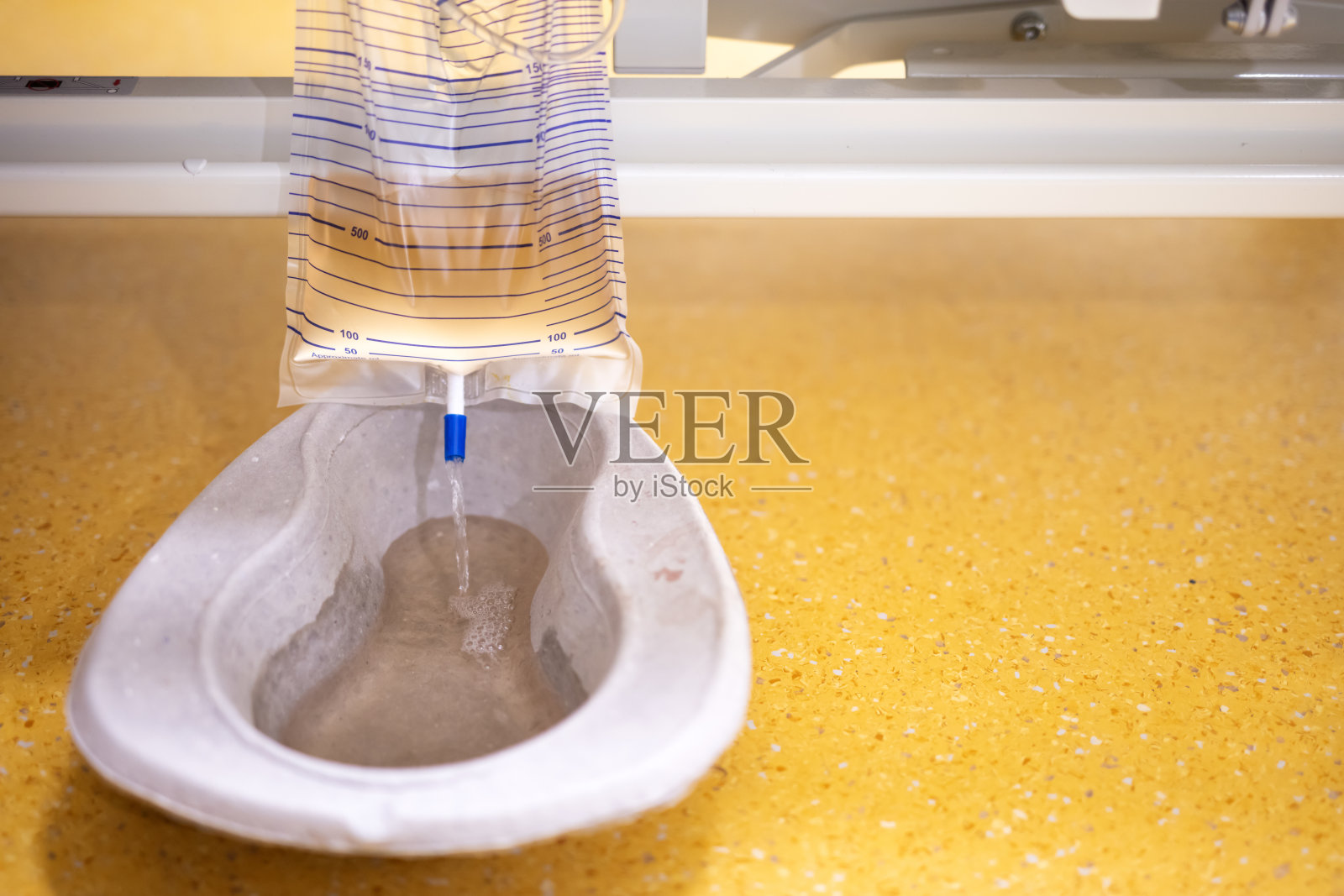 病人床下挂着塑料尿袋照片摄影图片