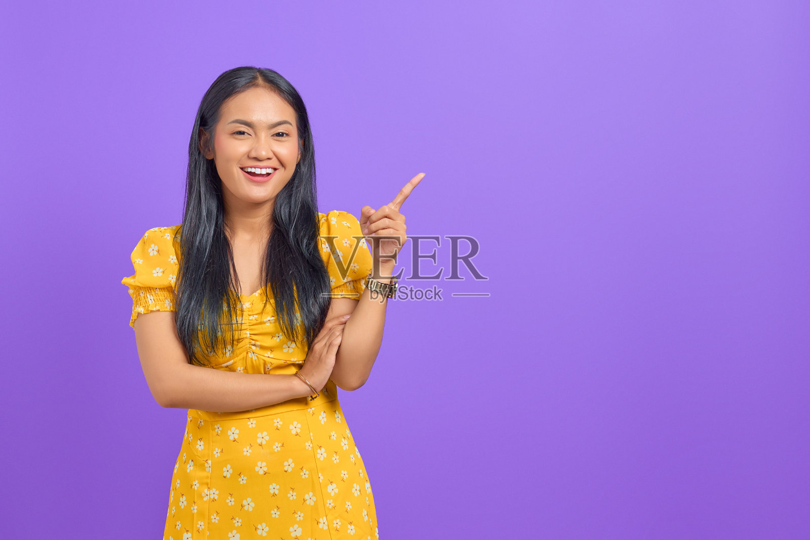 微笑的年轻亚洲女人的肖像指向复制空间紫色背景照片摄影图片