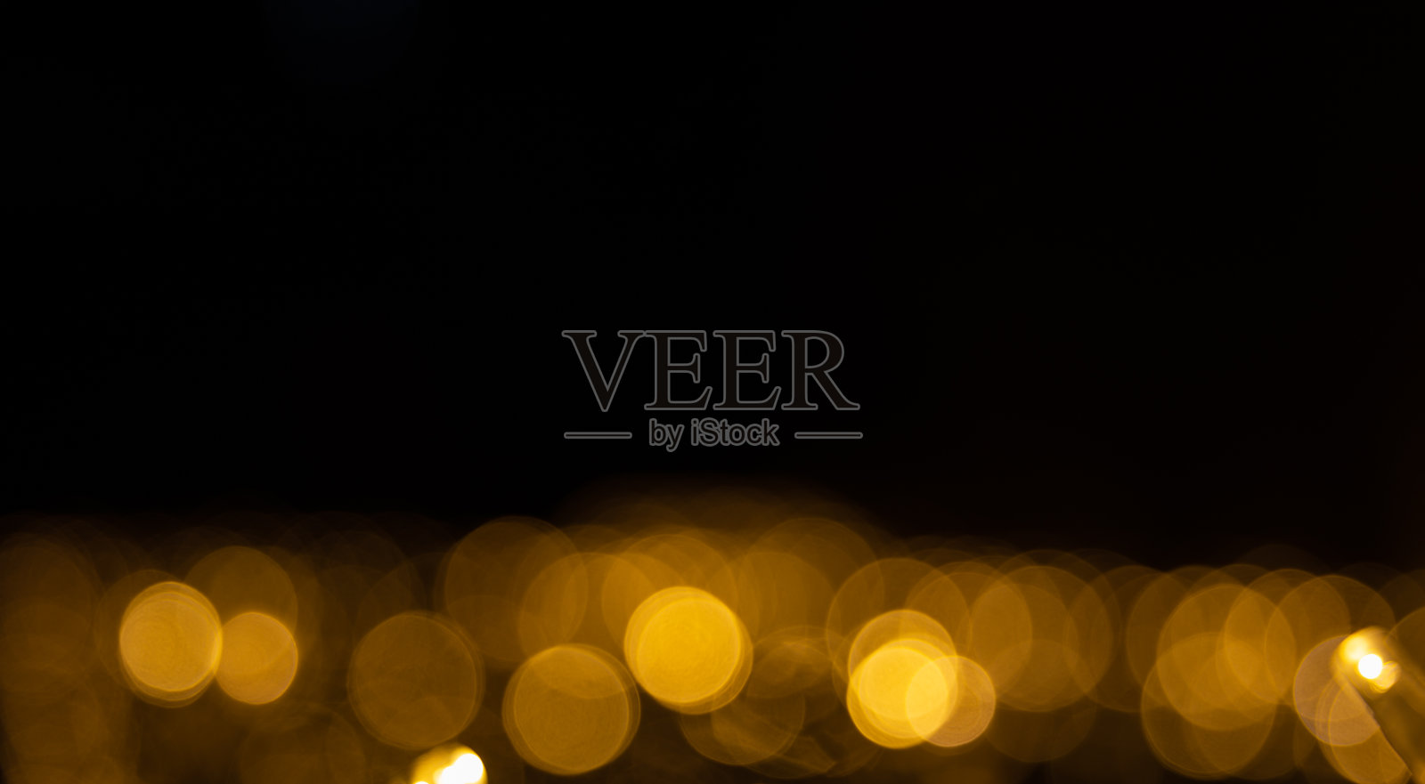 在黑色背景上散焦的黄色圣诞灯照片摄影图片