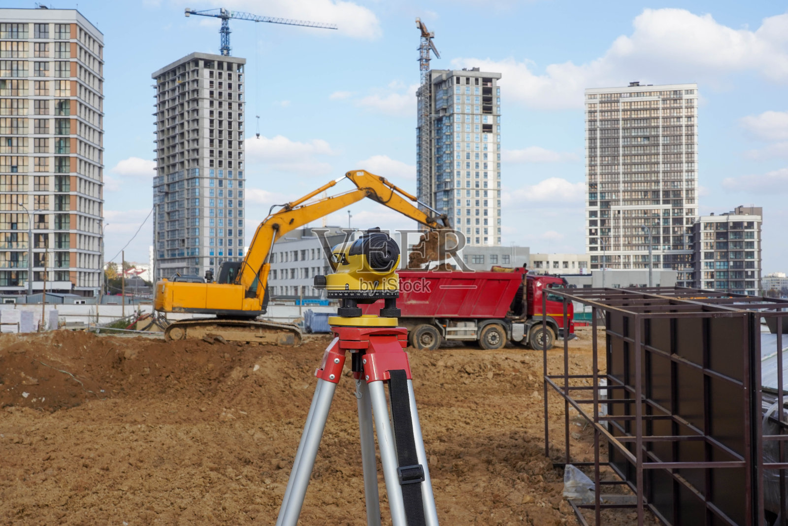 一辆黄色挖掘机和一辆红色卡车在城市街道上行驶照片摄影图片