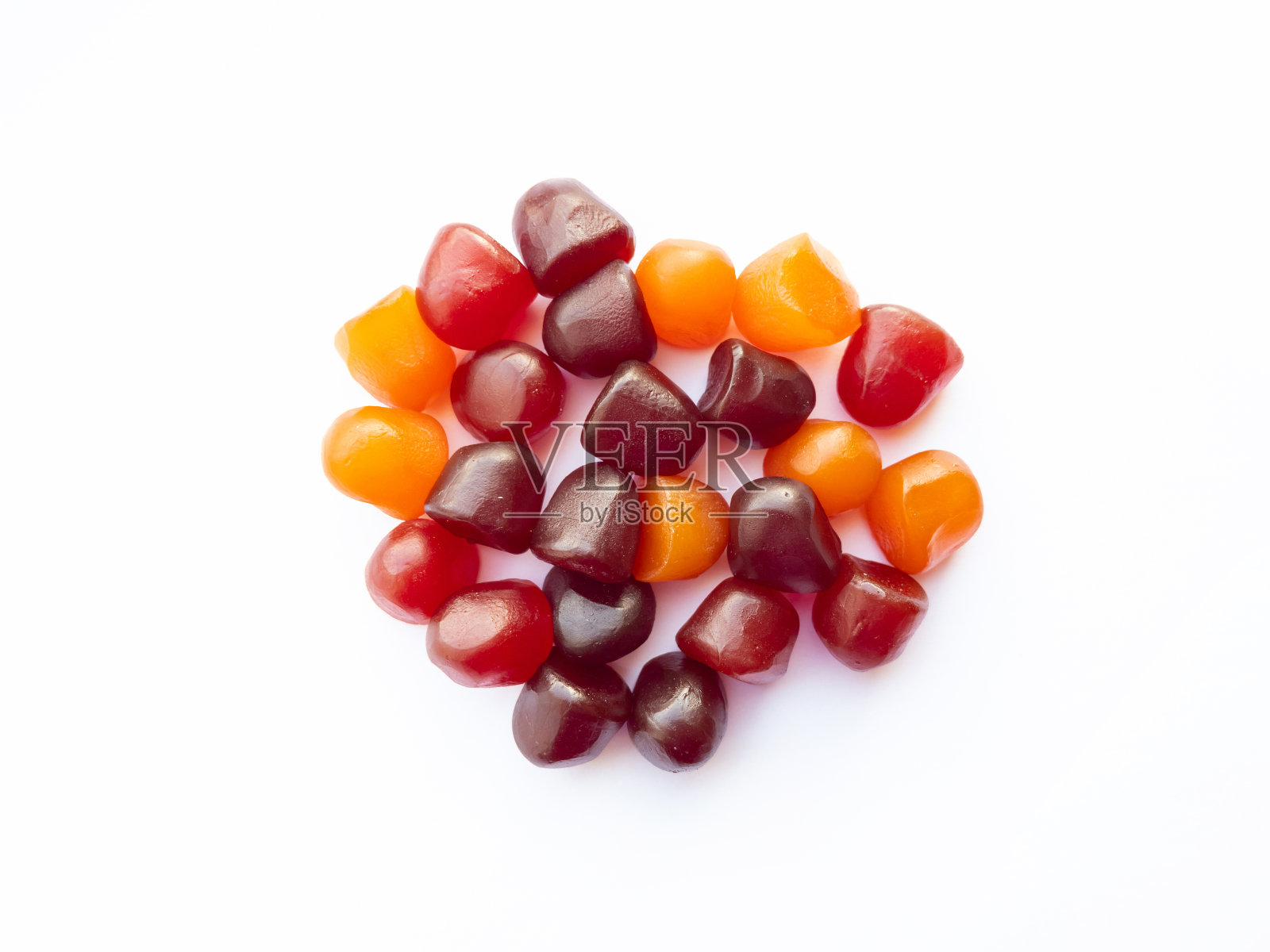 特写纹理的红色，橙色和紫色的复合维生素软糖在白色的背景。健康的生活方式的概念照片摄影图片