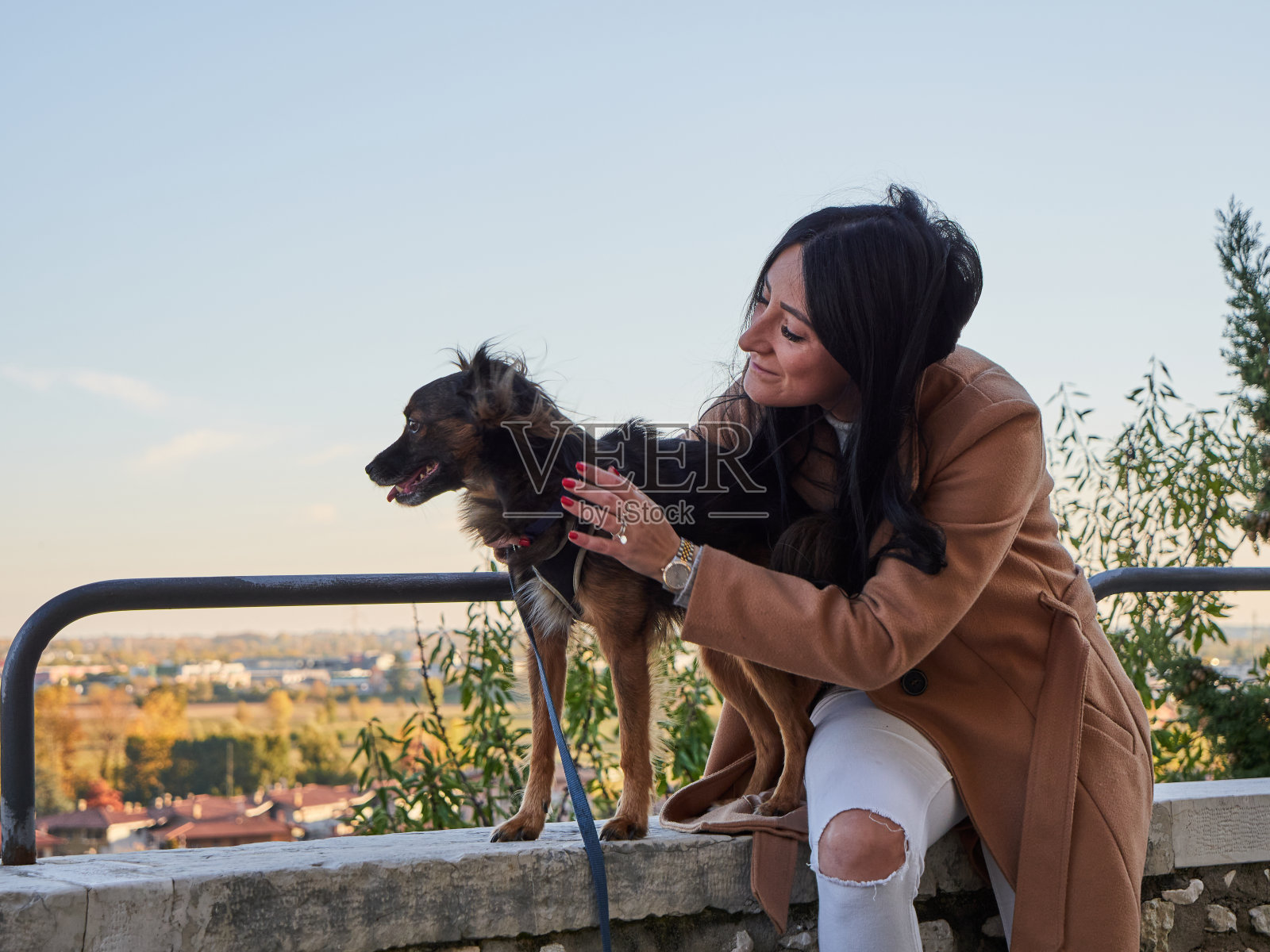 黑发女人和小狗玩照片摄影图片