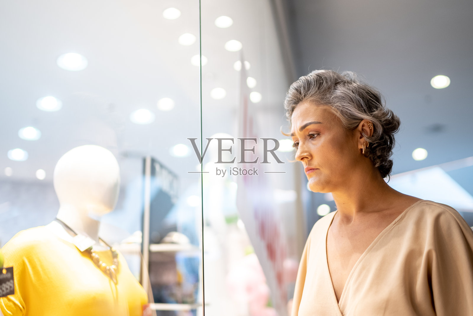 一个成熟的女人看着商场里的橱窗照片摄影图片