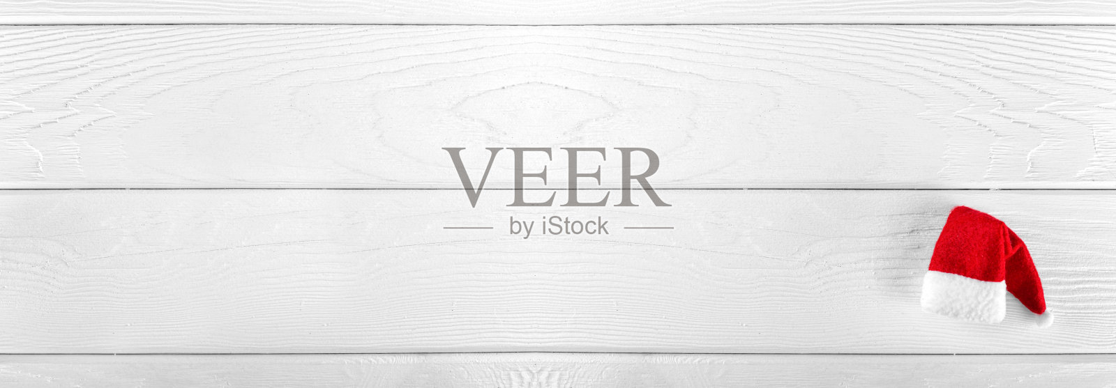 圣诞老人的帽子在白色木制背景。圣诞贺卡。长长的横幅照片摄影图片