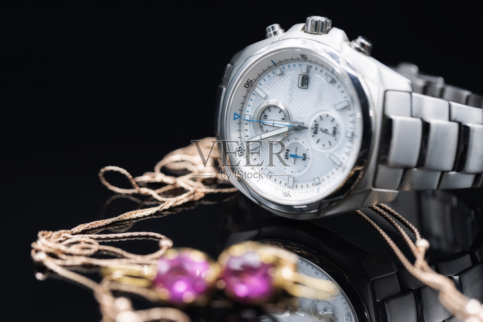 坚固的男士手表与精密计时器在钛的情况下躺在黄金的女性首饰的背景照片摄影图片