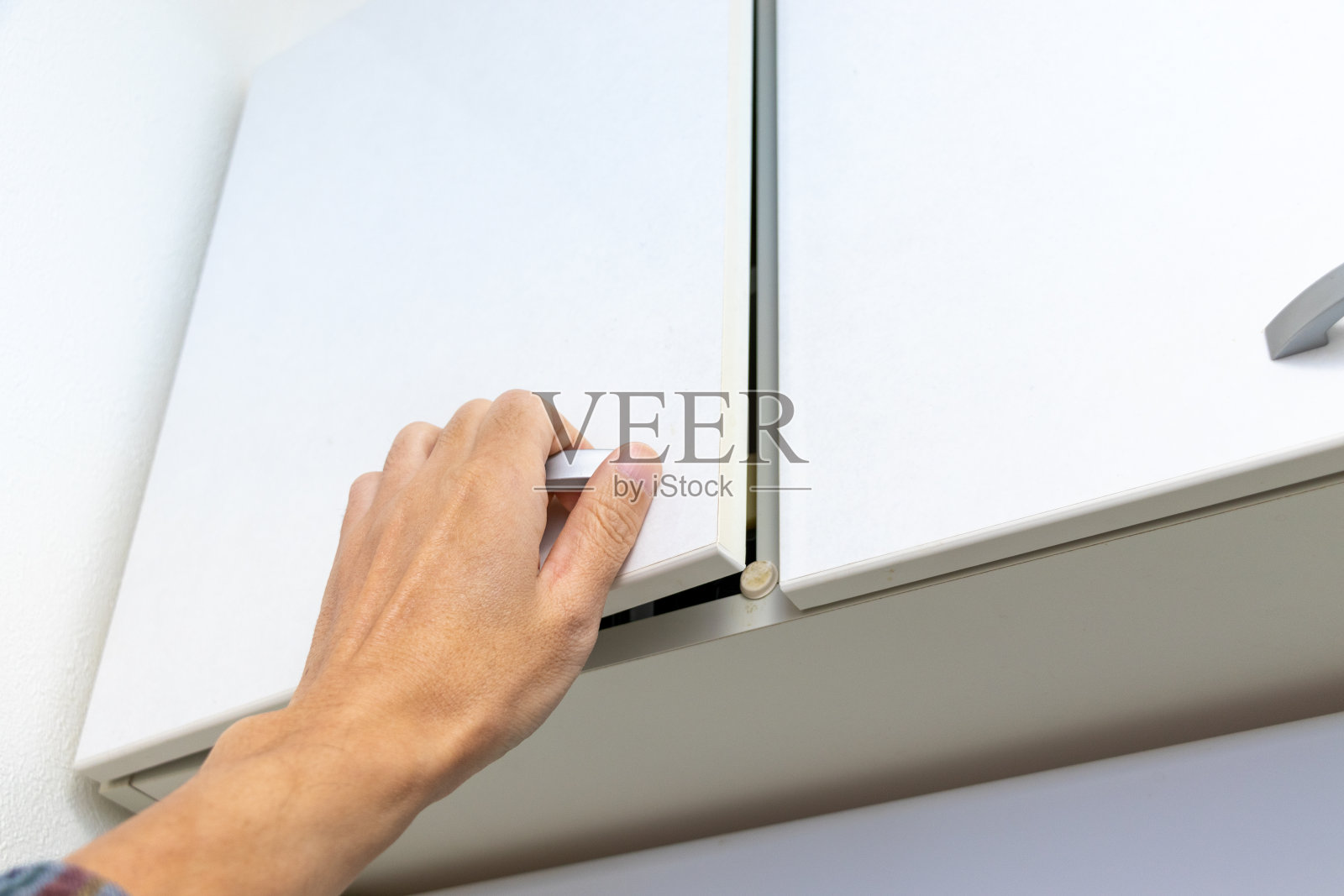 伸手打开高柜门照片摄影图片