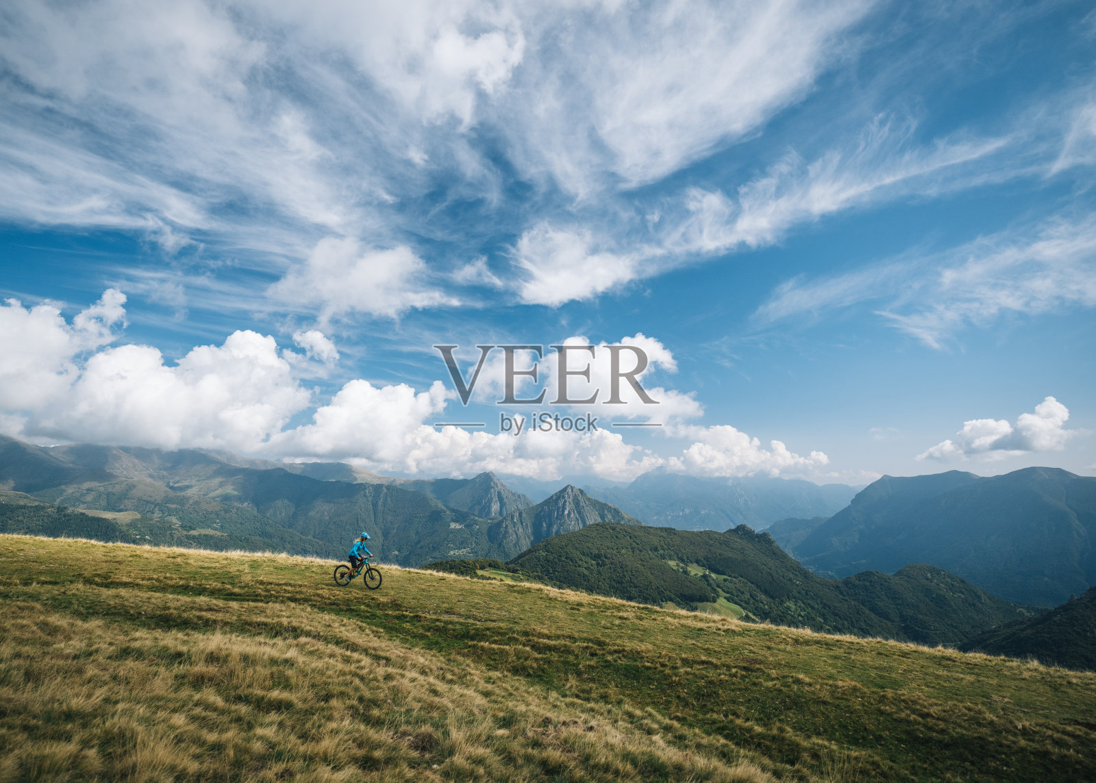 一名年轻女子骑山地车滑下草坡照片摄影图片
