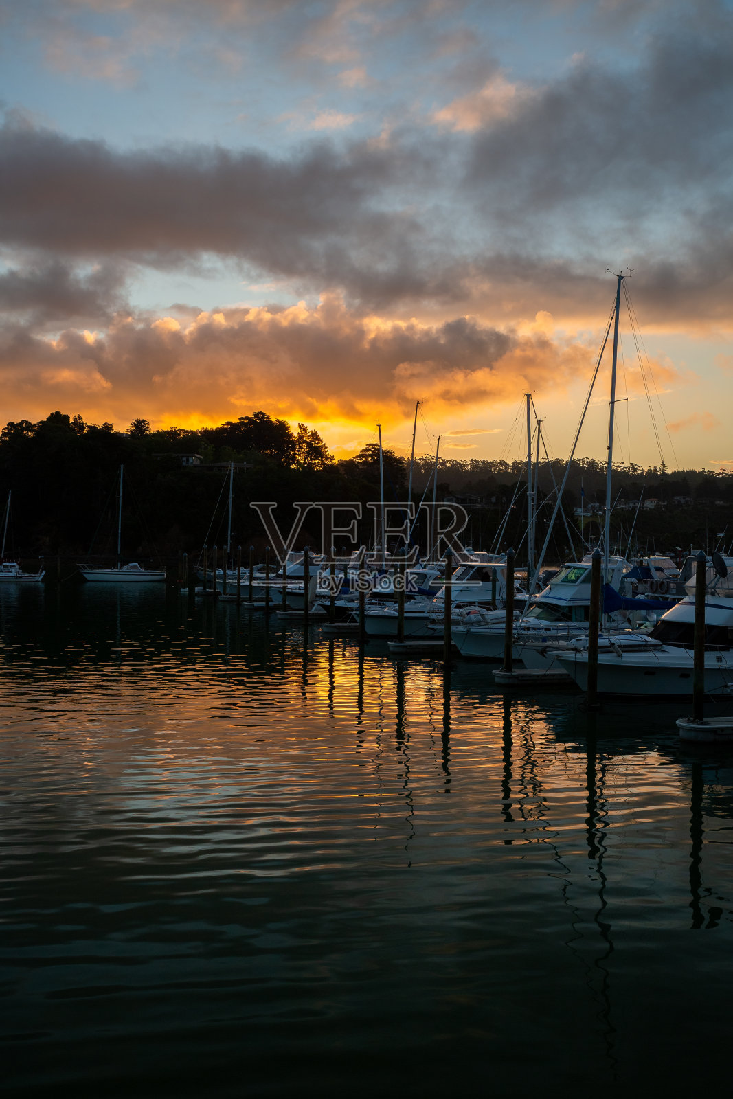 日落时分，新西兰图图卡卡的帆船停泊在码头上照片摄影图片