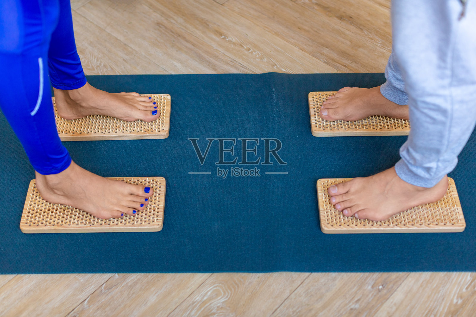 特写照片的一对夫妇的脚站在Sahu板与锋利的钉子照片摄影图片