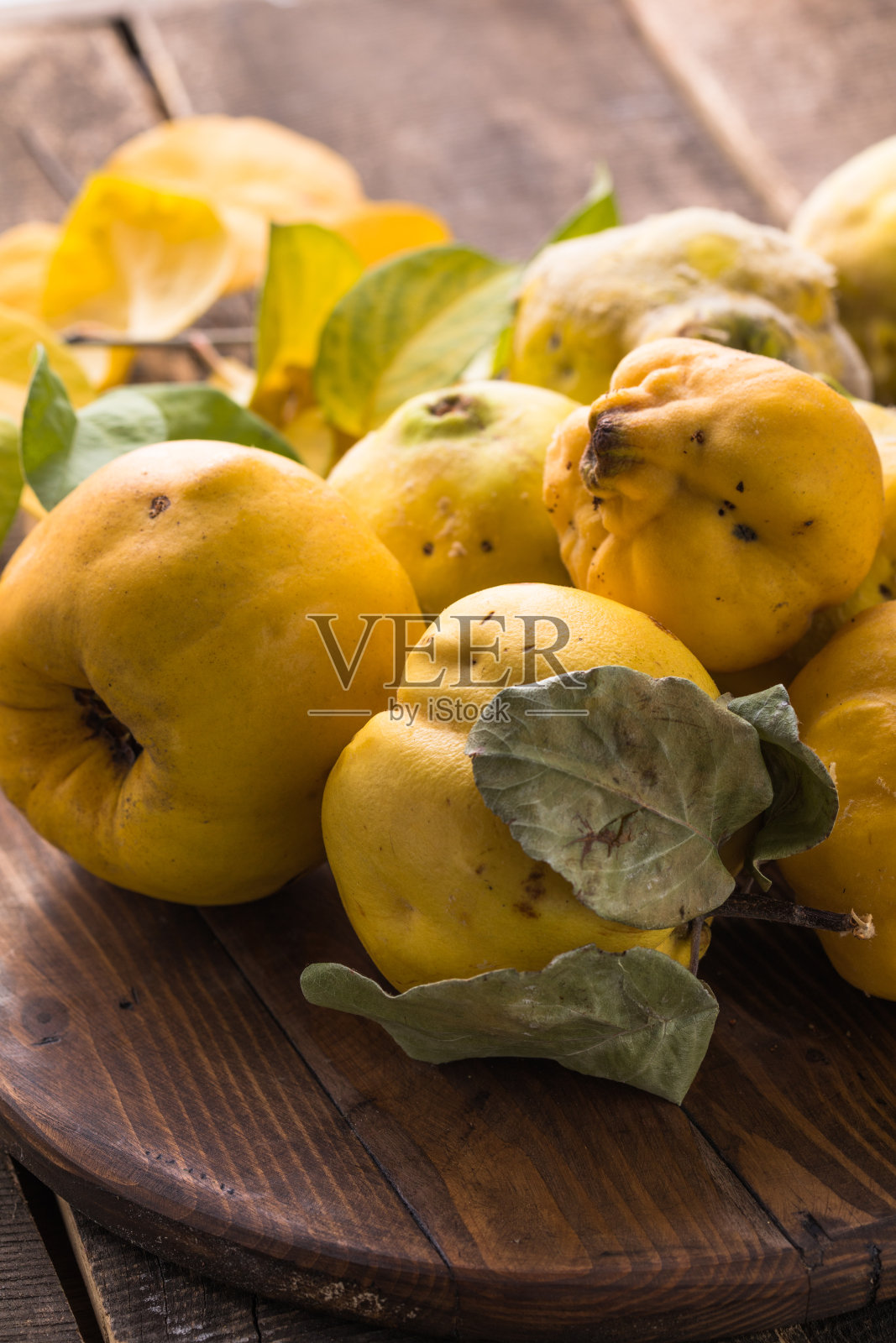 木制背景上的榅桲果。收获秋天的果实。照片摄影图片