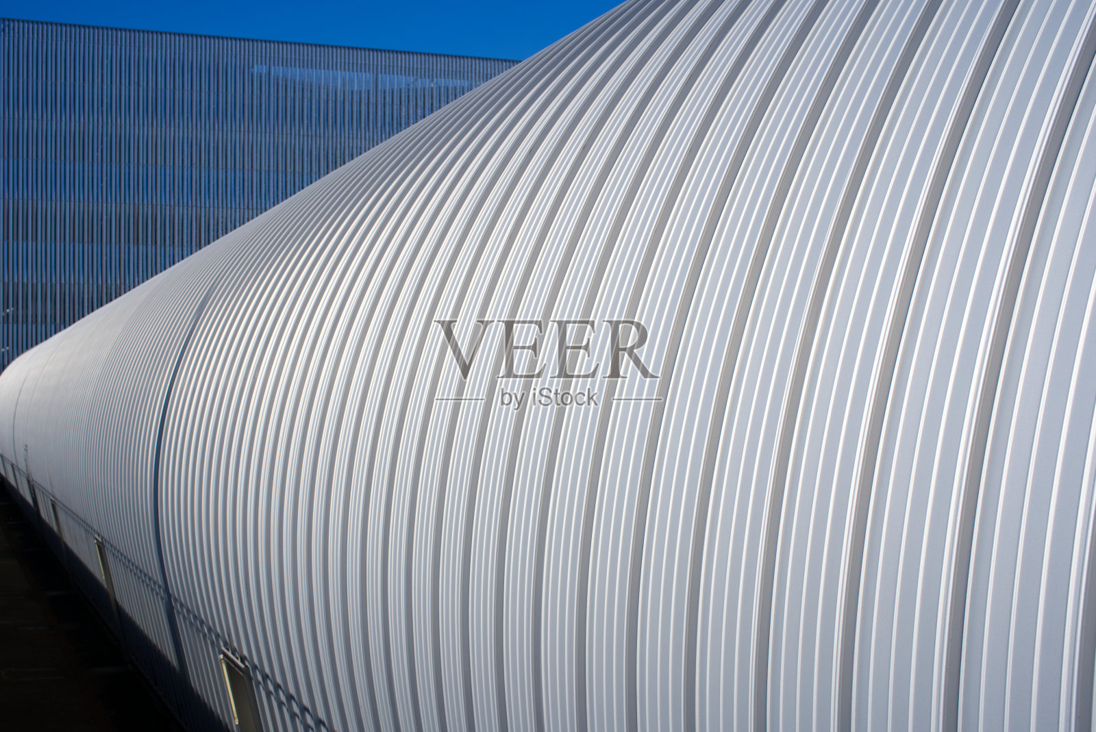 一个阳光明媚的秋日，Zürich机场仓库大楼的银色金属立面特写。照片摄影图片