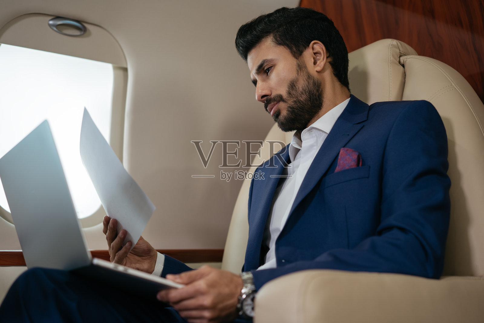 使用笔记本电脑阅读财务报告的中东商人照片摄影图片