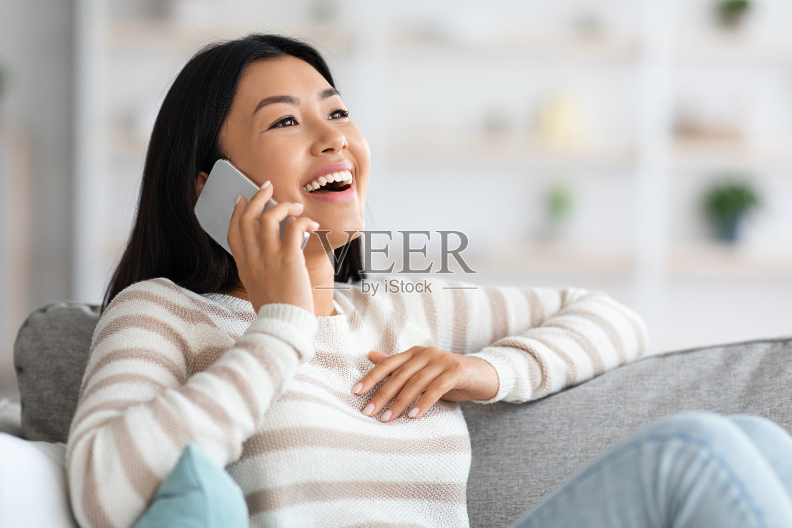 年轻的亚洲女士在家里用手机聊天的特写镜头照片摄影图片