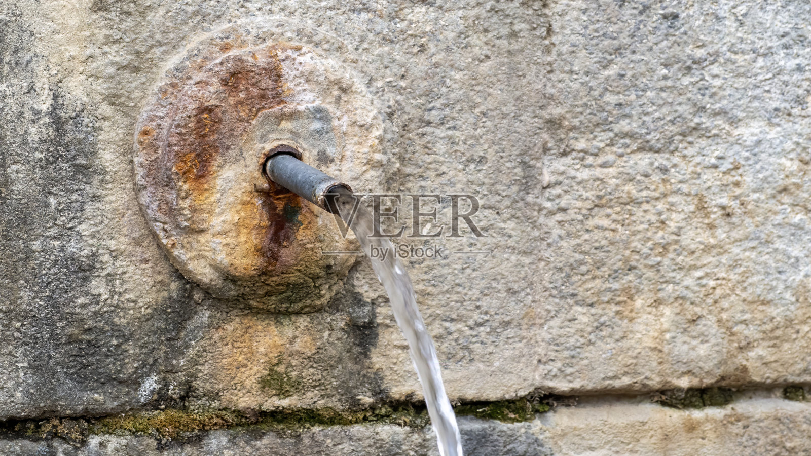 泉水从古老的天然石泉中流淌而出照片摄影图片
