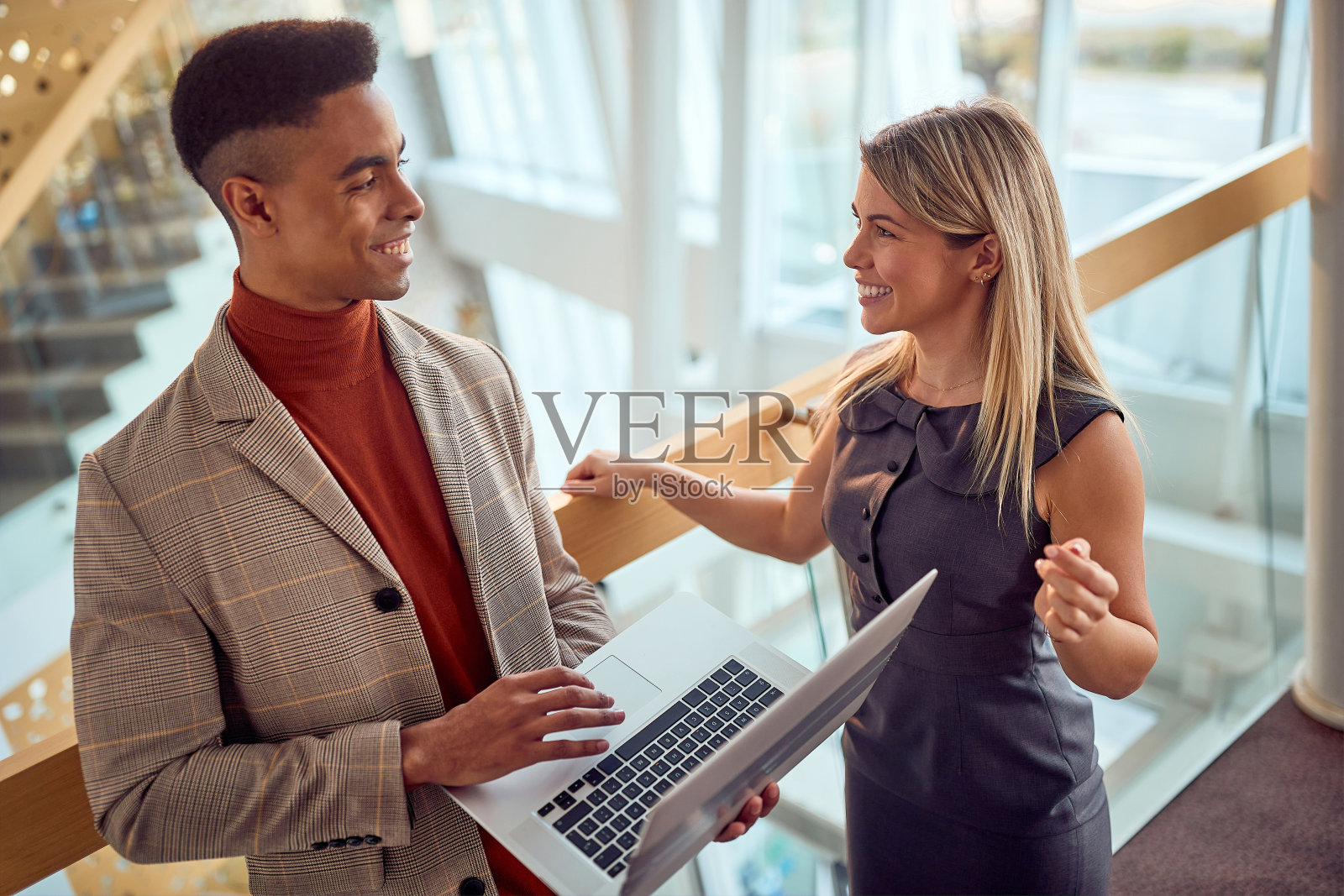 男人和女人站在大楼的走廊上工作照片摄影图片