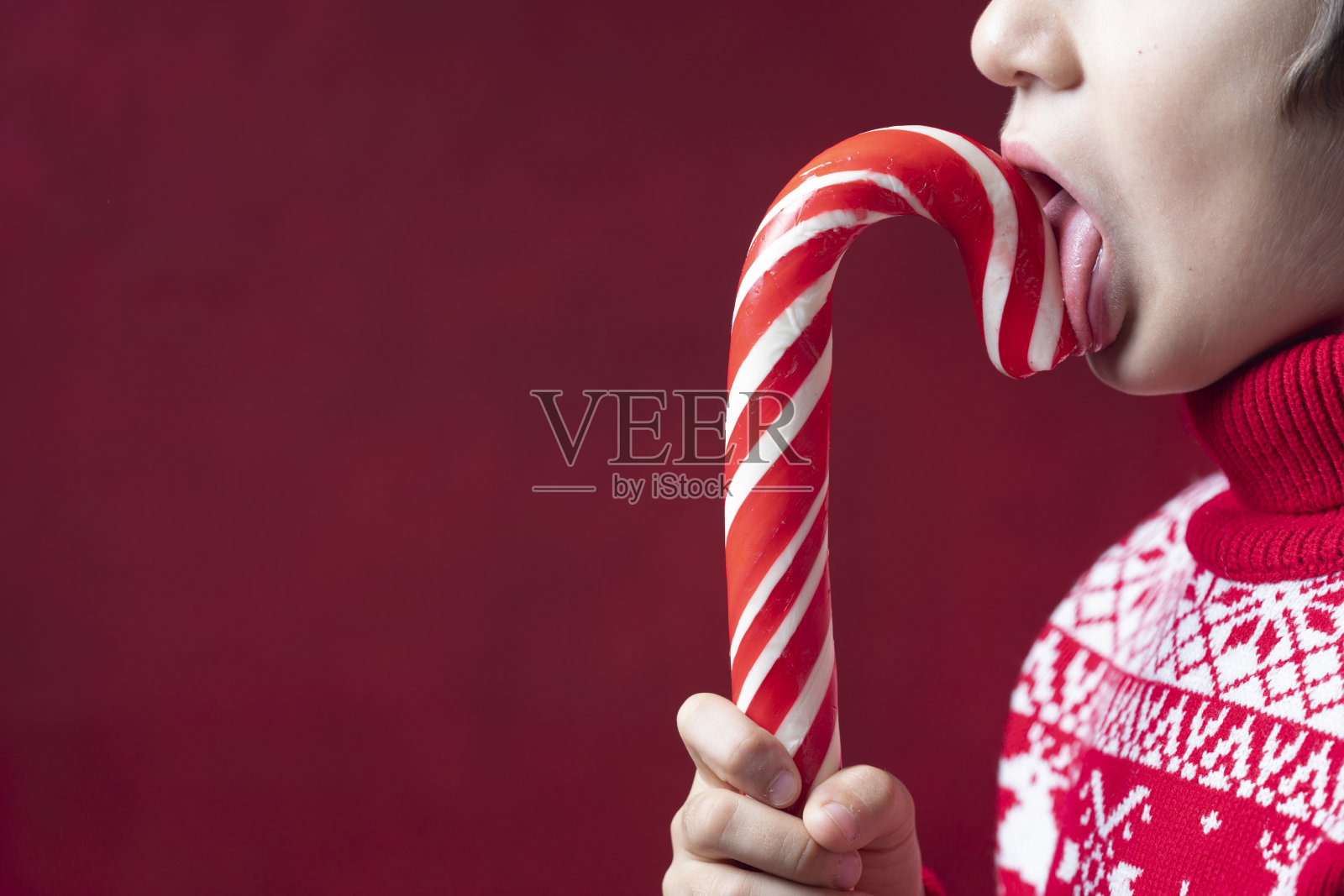 男孩吃圣诞拐杖糖的特写照片照片摄影图片