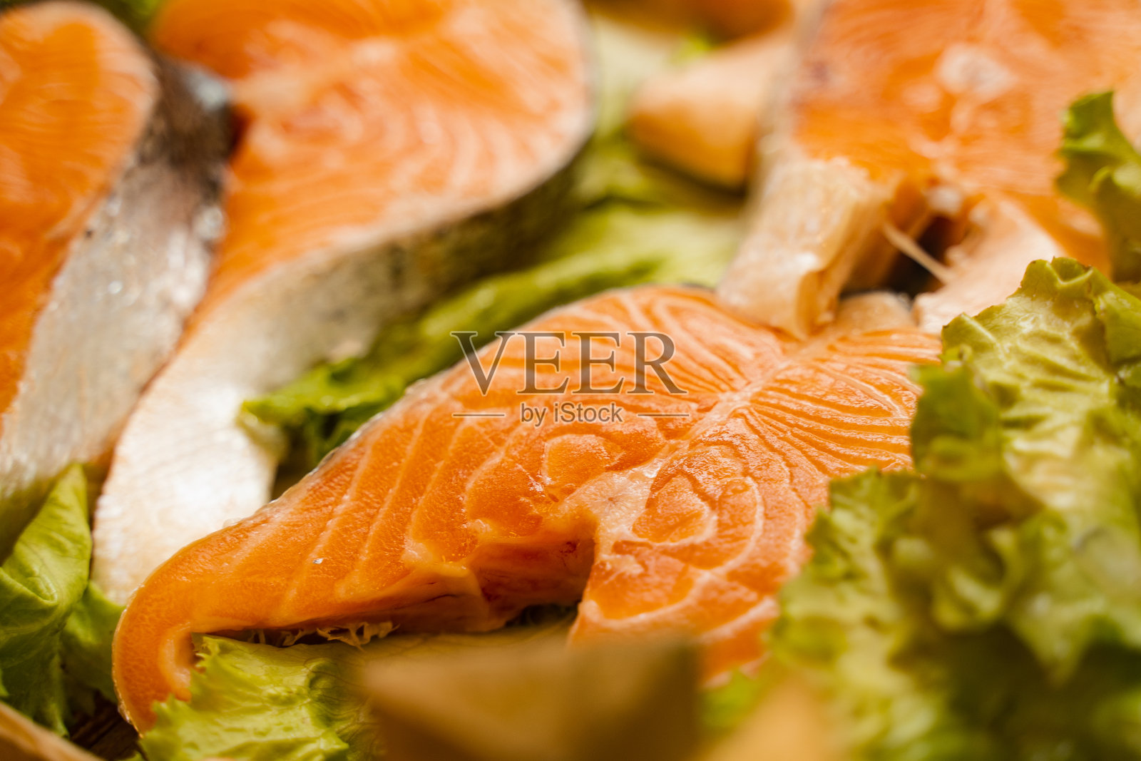 三文鱼排配生菜，特写镜头。新鲜的生红鱼。照片摄影图片