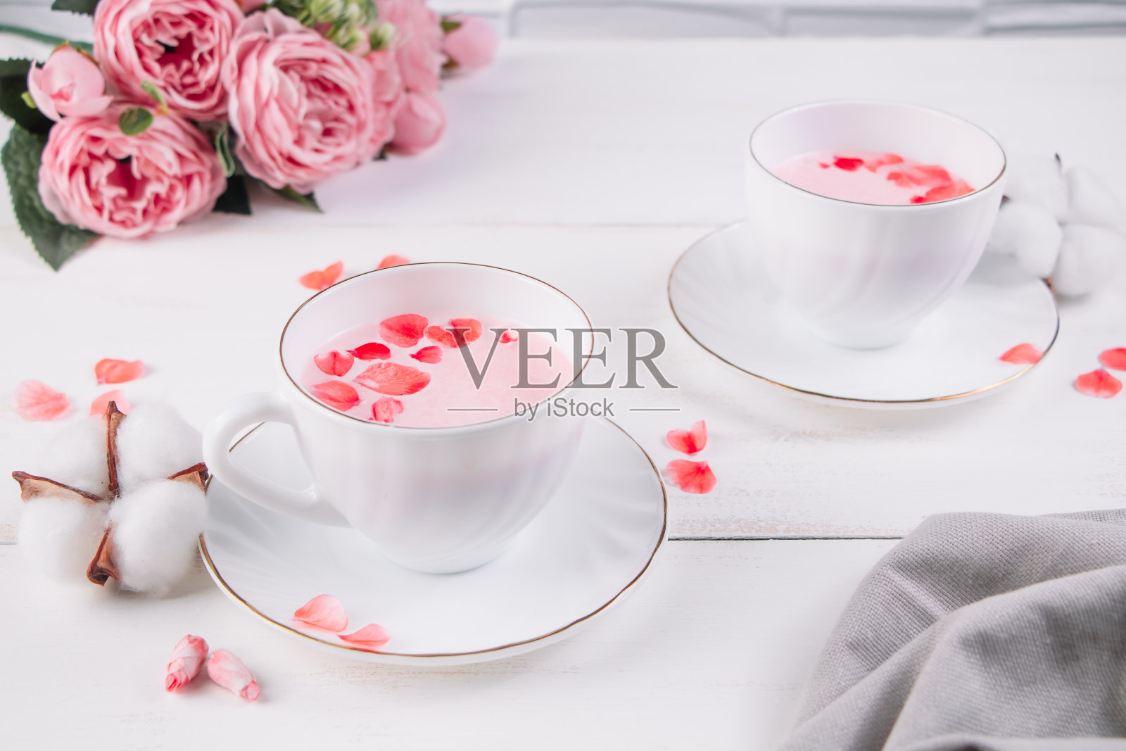 两杯粉色抹茶。放松饮料改善睡眠。流行的纯素茶在白色背景。照片摄影图片