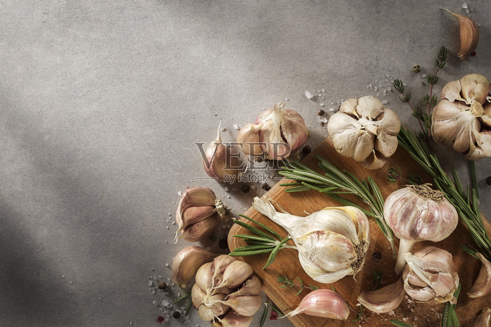 香料，香草，橄榄油在灰色的背景上。大蒜，迷迭香，欧芹，俯视图。照片摄影图片