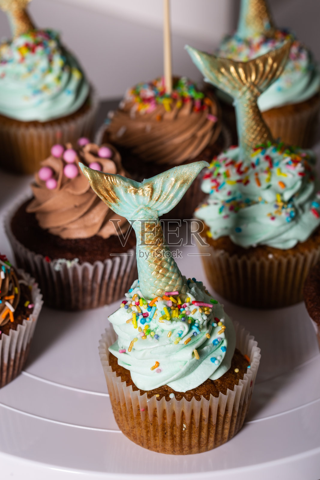 美人鱼尾巴，绿糖纸杯蛋糕松饼，仍然在一个主题生日派对照片摄影图片