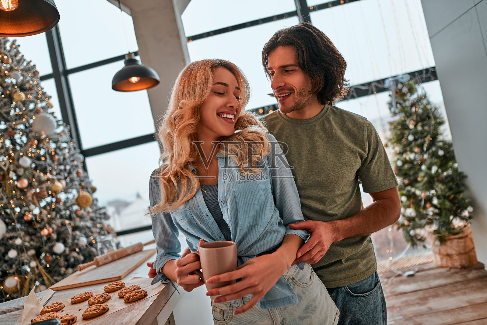 一对情侣在厨房里喝咖啡。圣诞节的早晨。照片摄影图片