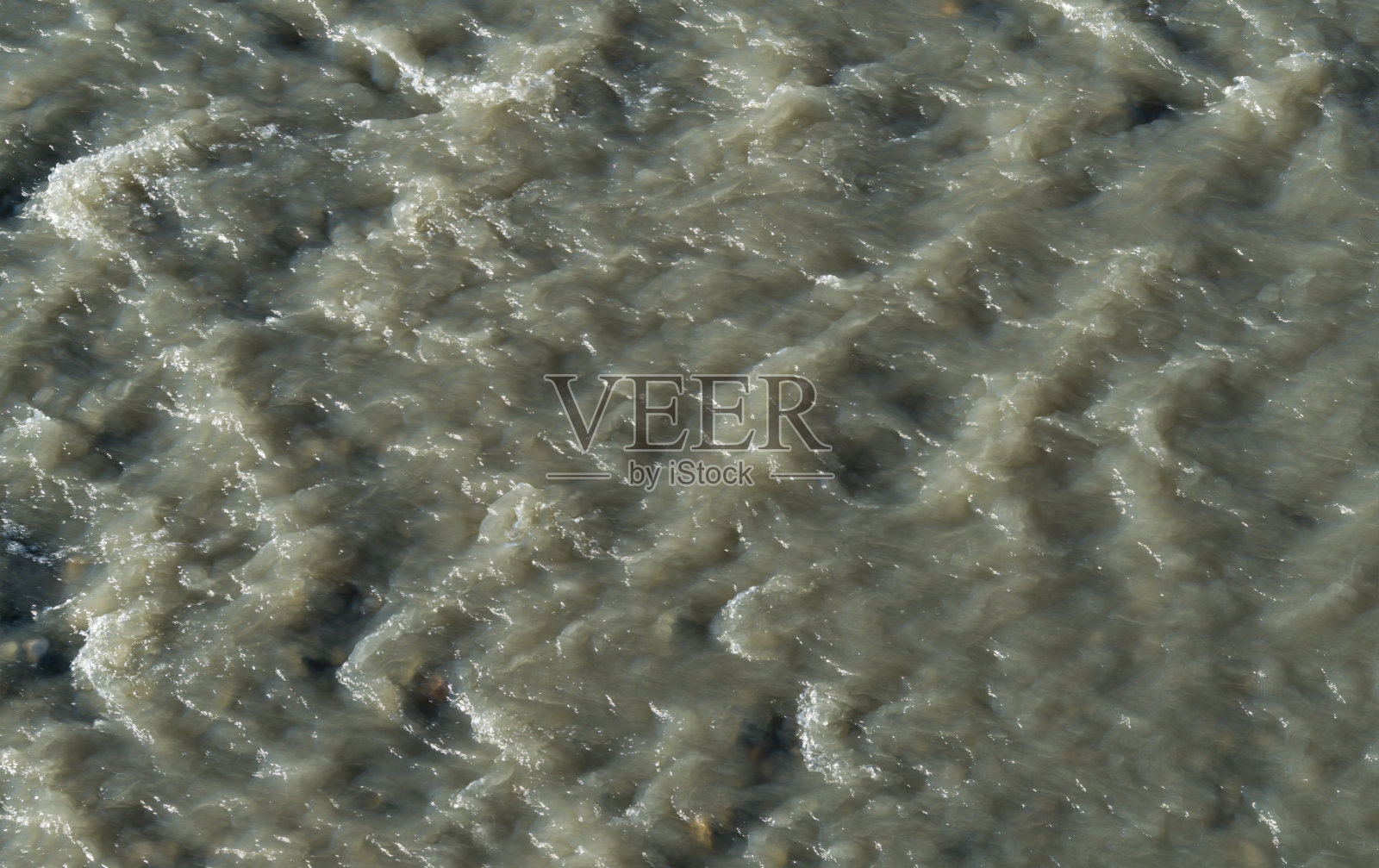 阿德勒浑浊沸水山河Mzymta的特写镜头。在浅滩上的岩石间。有趣的快速斑点灰色背景为任何设计。照片摄影图片