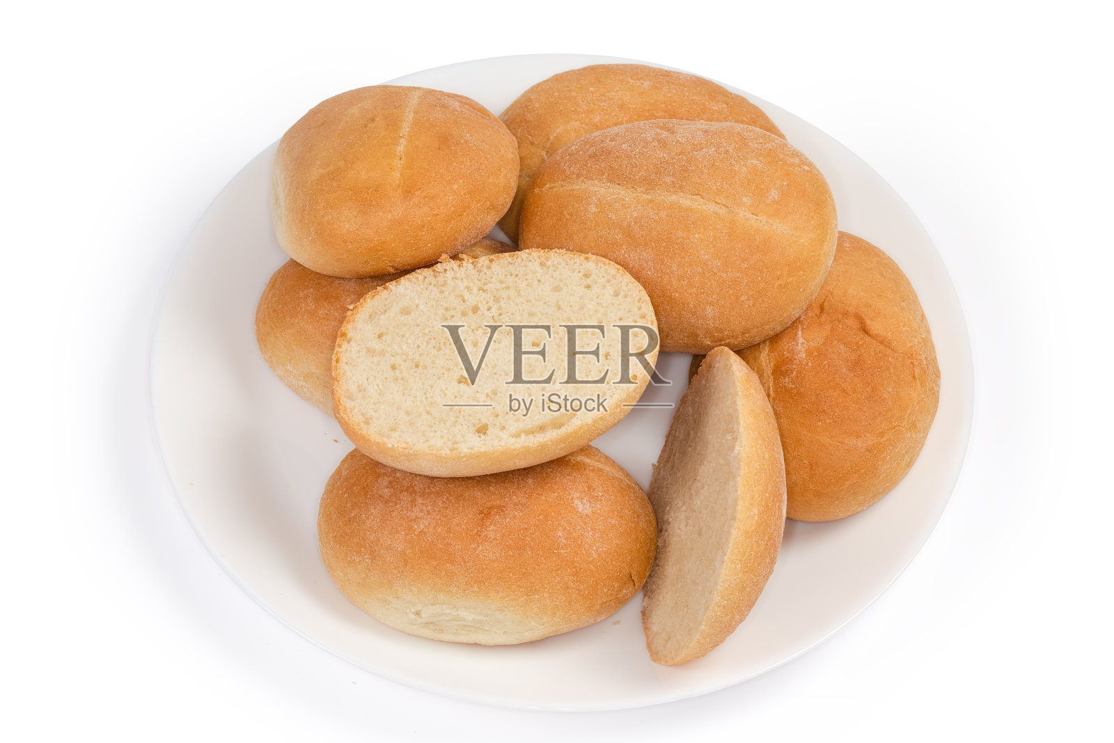 一堆小面包，其中一个横切在盘上照片摄影图片