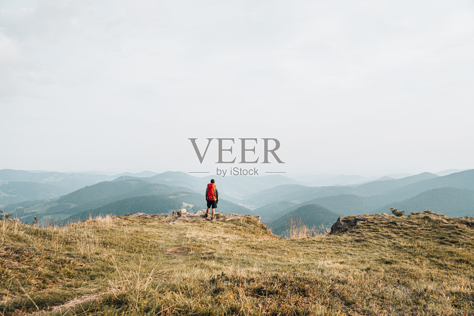 徒步旅行者在长满草的山脊上放松的观点照片摄影图片