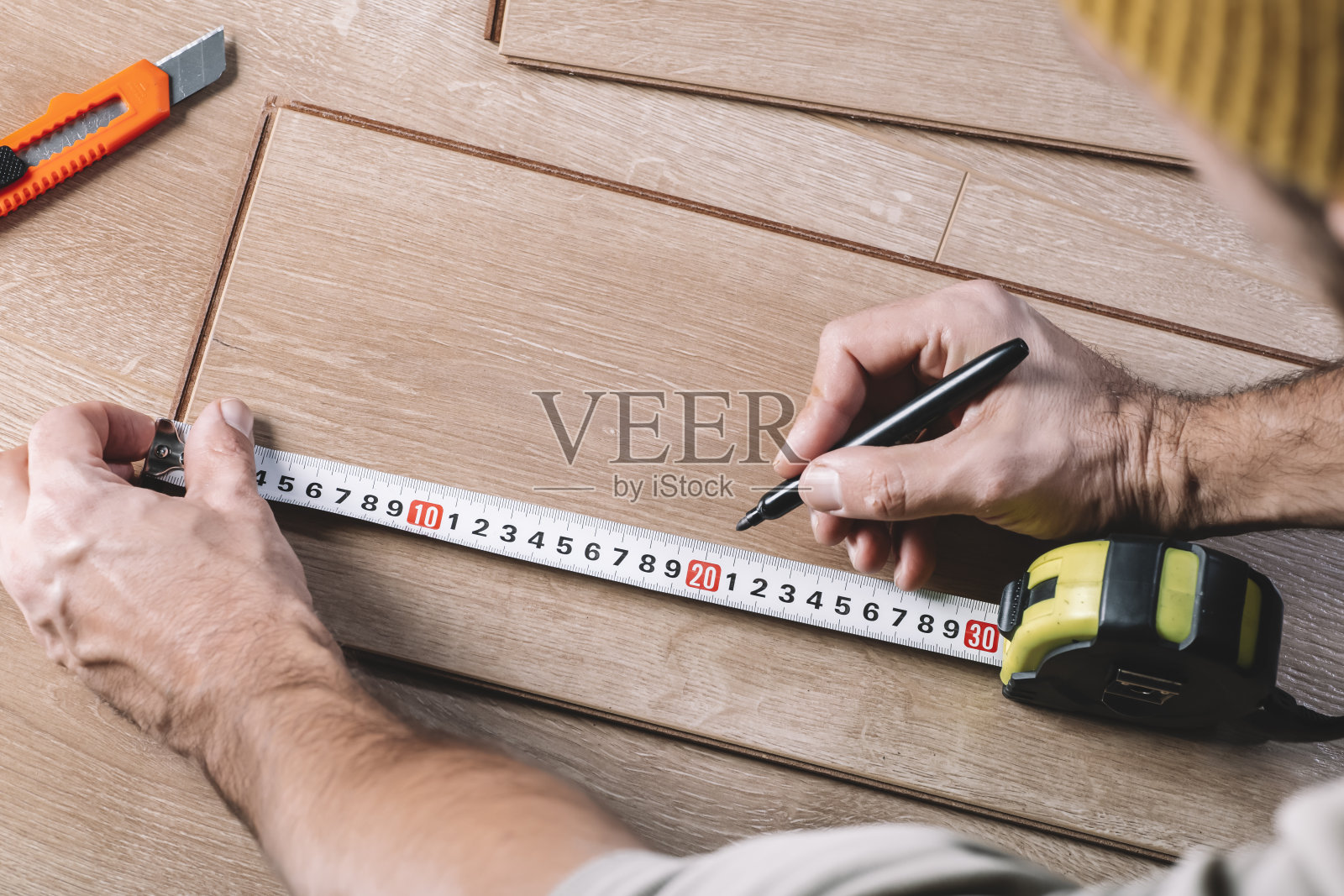 在房间或办公室安装强化地板。木制拼花地板及工具。房屋装修的建筑和装饰工程照片摄影图片