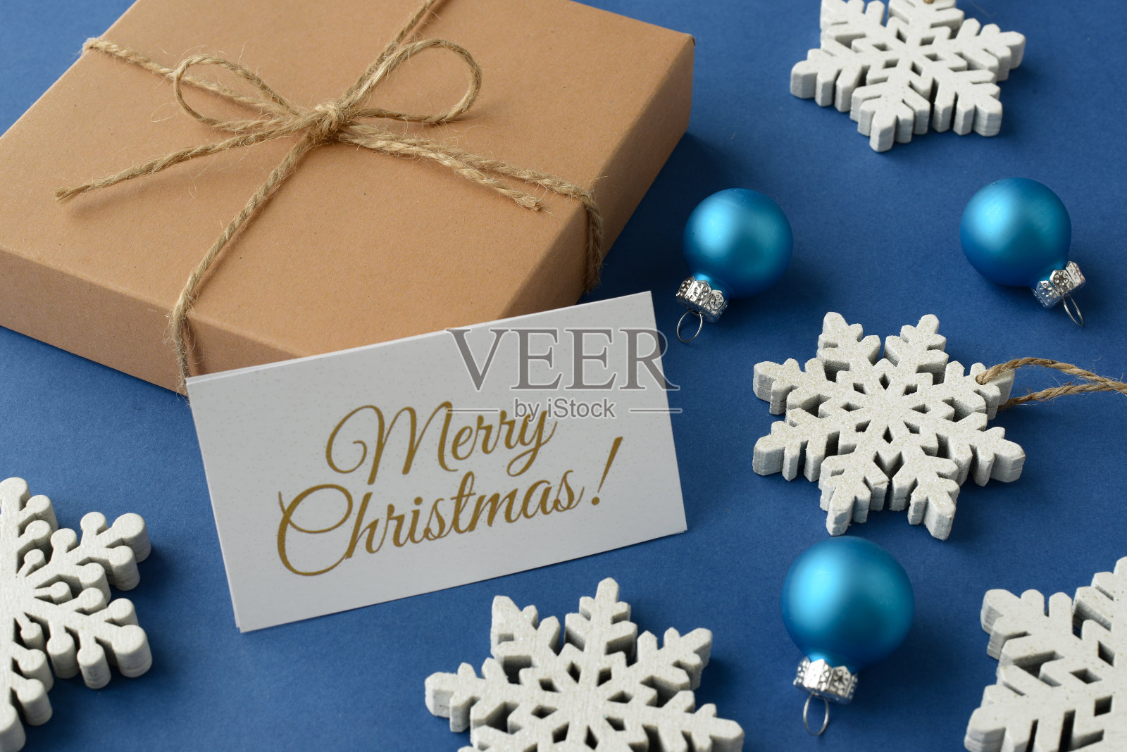 圣诞组成。圣诞礼物，白色的雪花，装饰圣诞树的蓝色玻璃球和蓝色背景上的圣诞贺卡。俯视图照片摄影图片