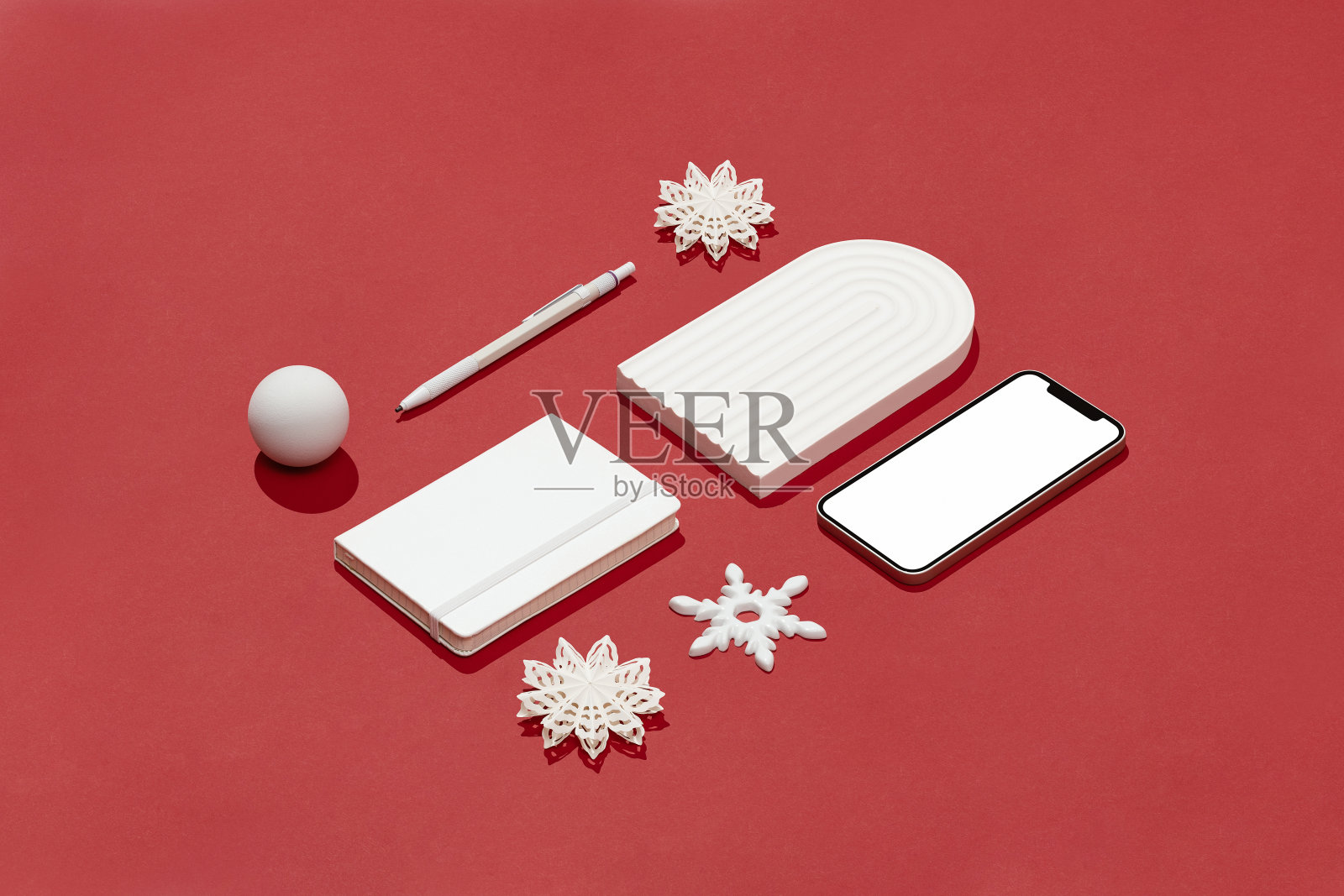 白色圣诞节概念平放在红色背景与智能手机模型照片摄影图片