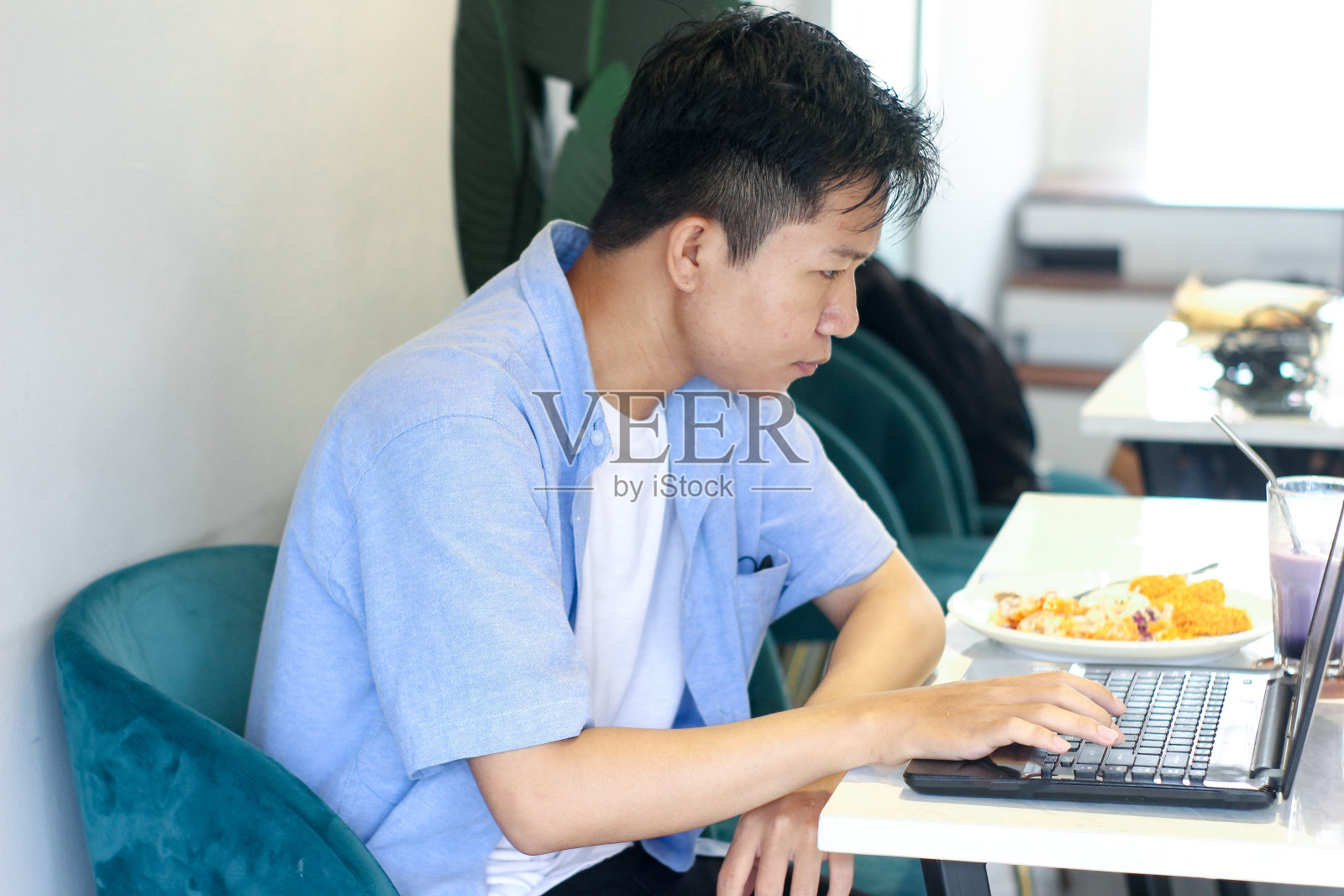 在咖啡馆用笔记本电脑工作的年轻人照片摄影图片