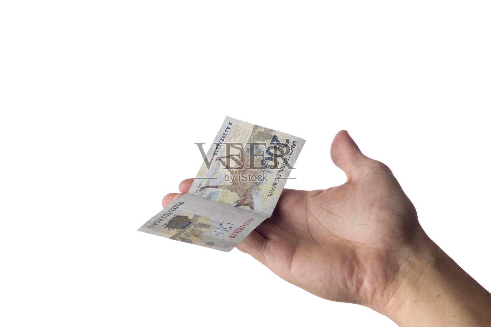 拿着200雷亚尔钞票的男子被隔离在白色上。巴西的钱。支付。照片摄影图片