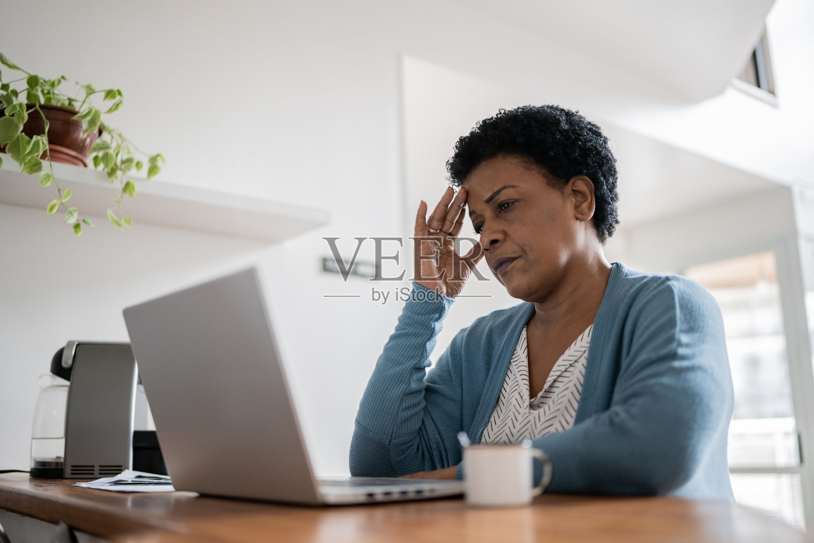 悲伤的成熟女性头痛在家工作照片摄影图片