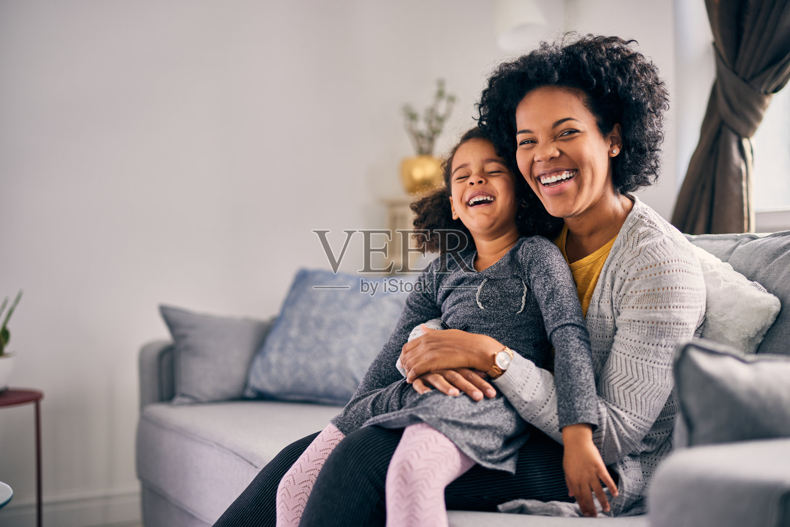 快乐的成年妇女，拥抱着她的小女儿照片摄影图片