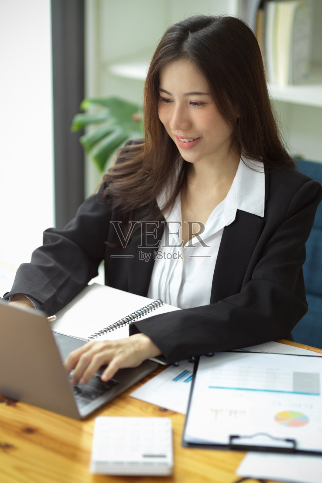 助理，秘书，使用笔记本电脑工作的员工。照片摄影图片