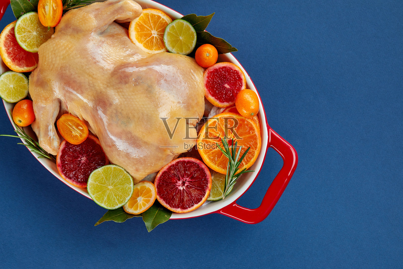 香草和柑橘烤箱烤鸡。整只鸡放在烤盘里，配上柠檬和香草，准备进入烤箱。俯视图，空白照片摄影图片