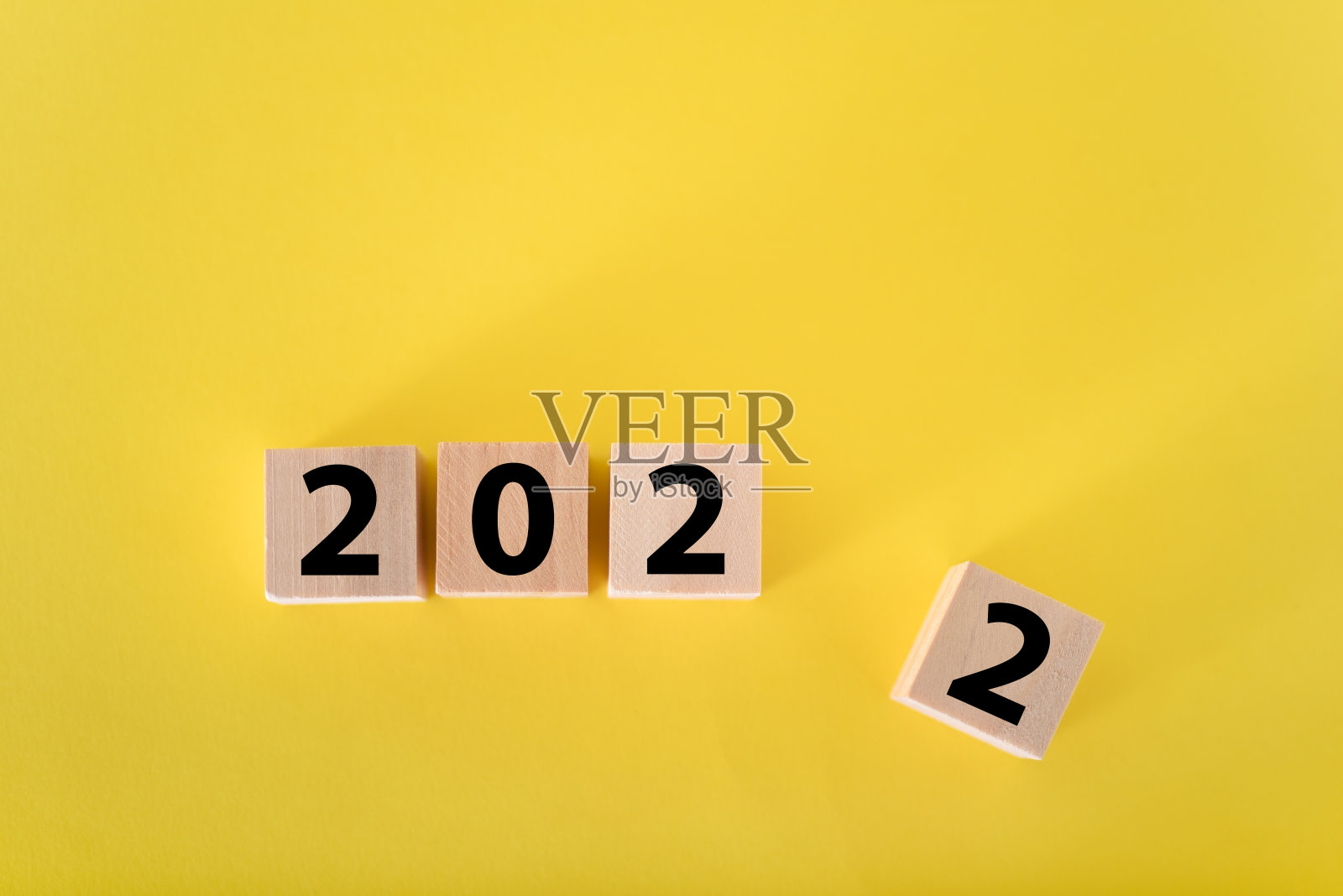 黄色背景上的木方块和2022。照片摄影图片